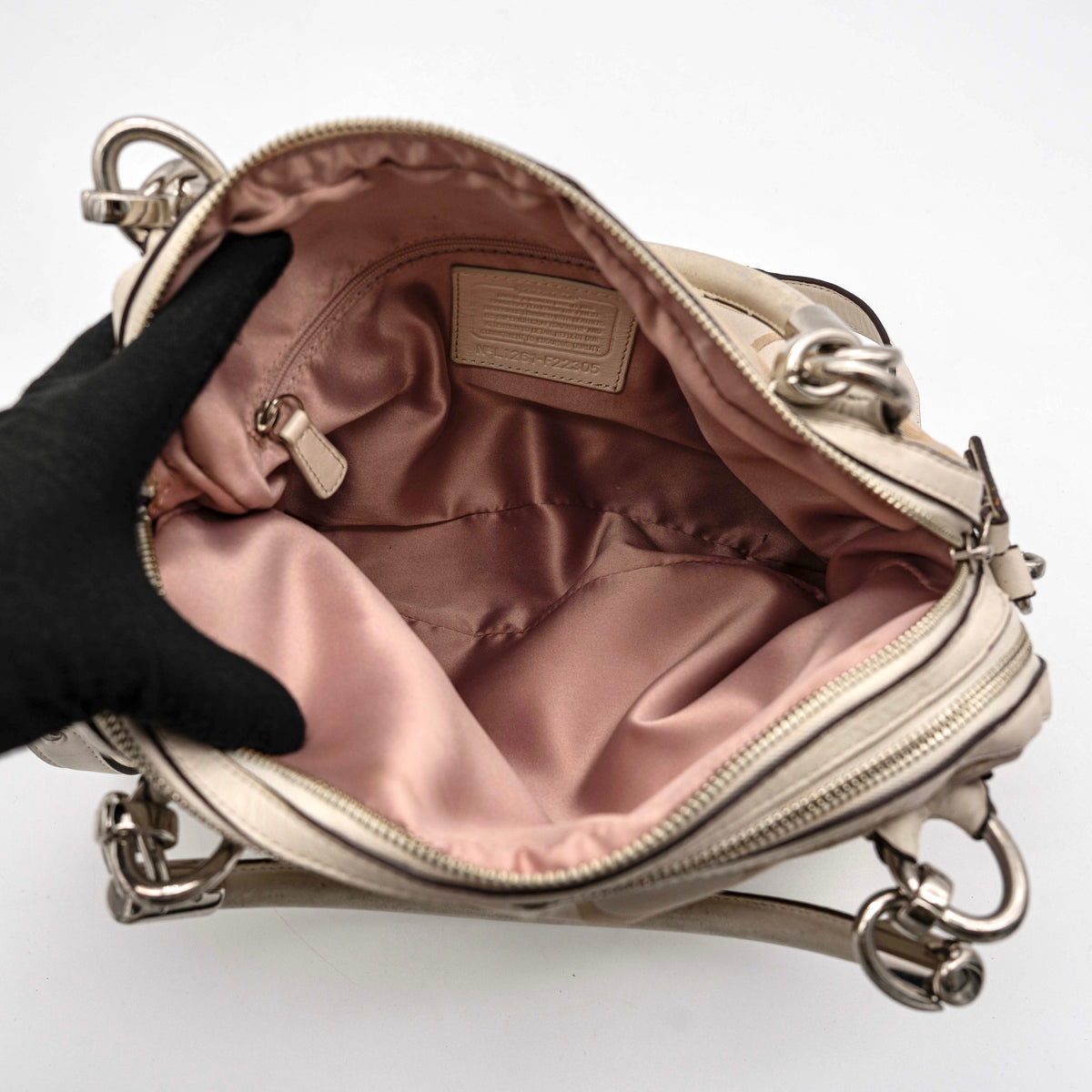 Coach Signature Kristin Satchel handbag in beige and cream jacquard with leather trim and detachable strap, displayed against a white background.