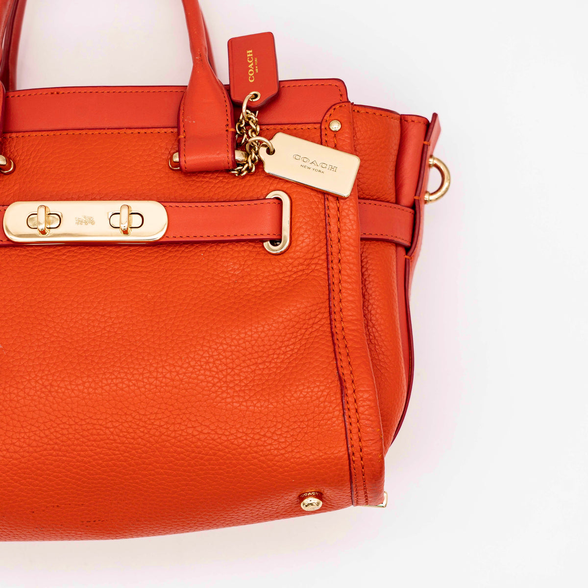 Coach Swagger 27 Carryall in textured red leather with gold hardware, shown with detachable shoulder strap.