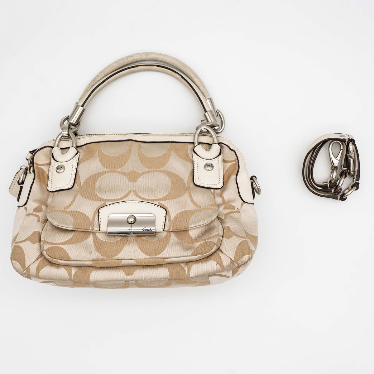 Coach Signature Kristin Satchel handbag in beige and cream jacquard with leather trim and detachable strap, displayed against a white background.