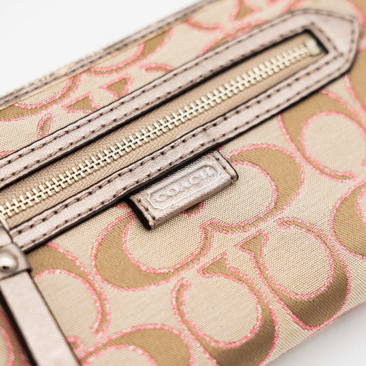 Coach Signature Daisy Accordion Zip Wallet in beige and pink canvas with zip pocket and metallic trim, photographed on a white background.
