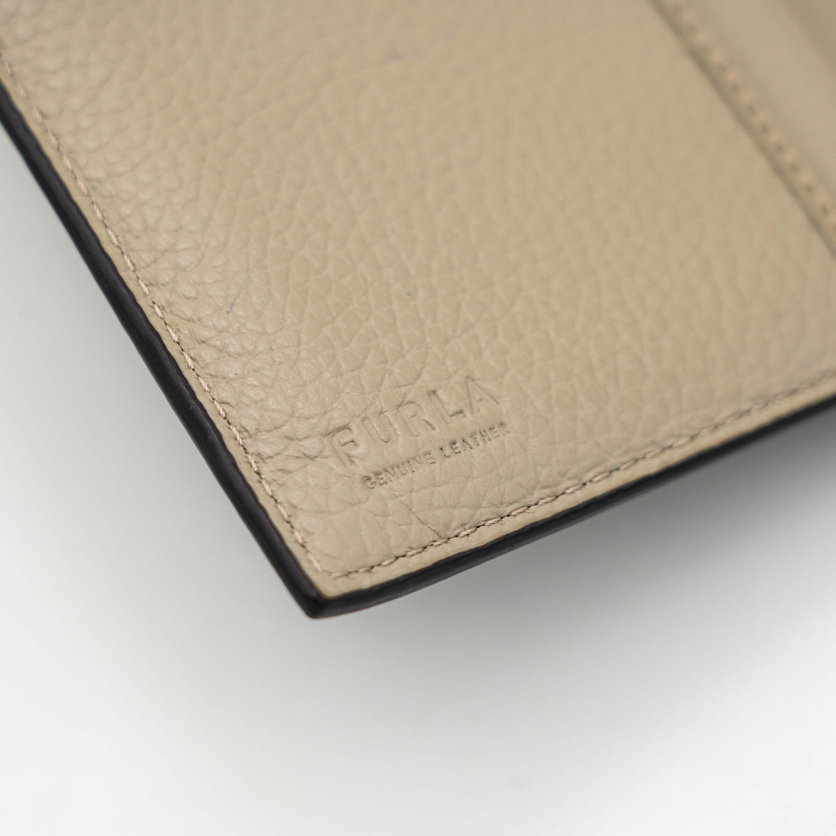Furla Dafne black trifold wallet in pebbled leather with gold-tone hardware and logo plaque on the front.