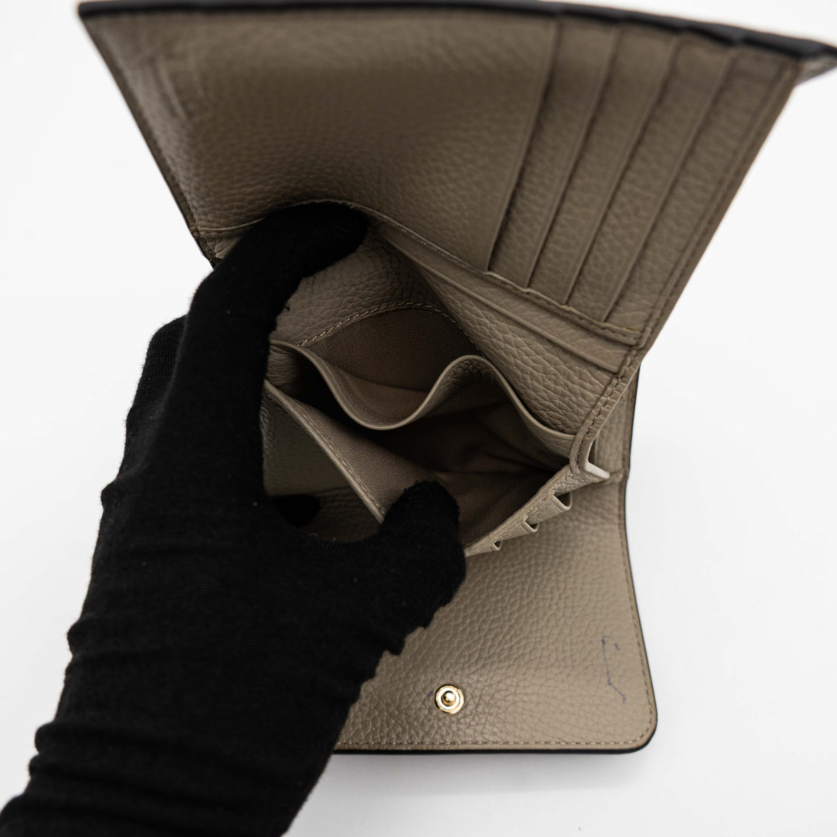 Furla Dafne black trifold wallet in pebbled leather with gold-tone hardware and logo plaque on the front.