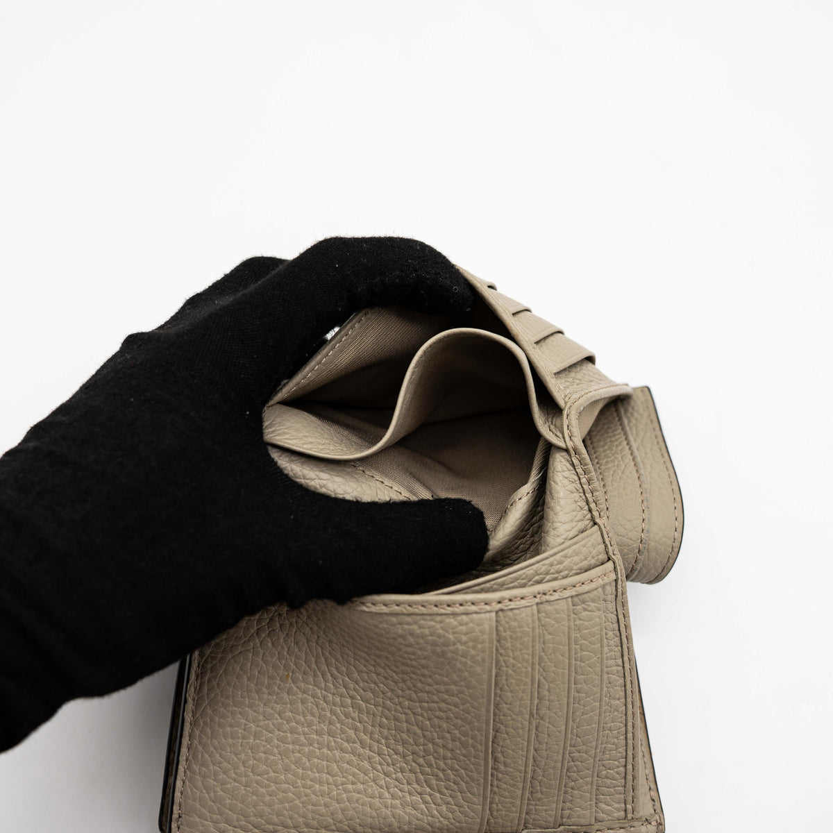 Furla Dafne black trifold wallet in pebbled leather with gold-tone hardware and logo plaque on the front.