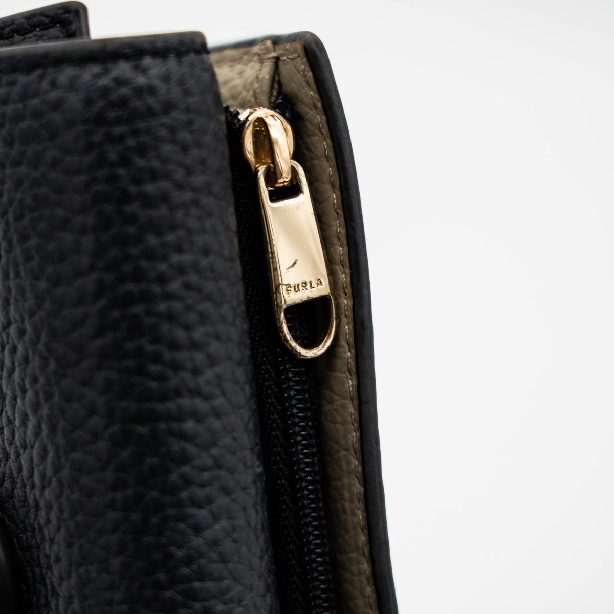 Furla Dafne black trifold wallet in pebbled leather with gold-tone hardware and logo plaque on the front.