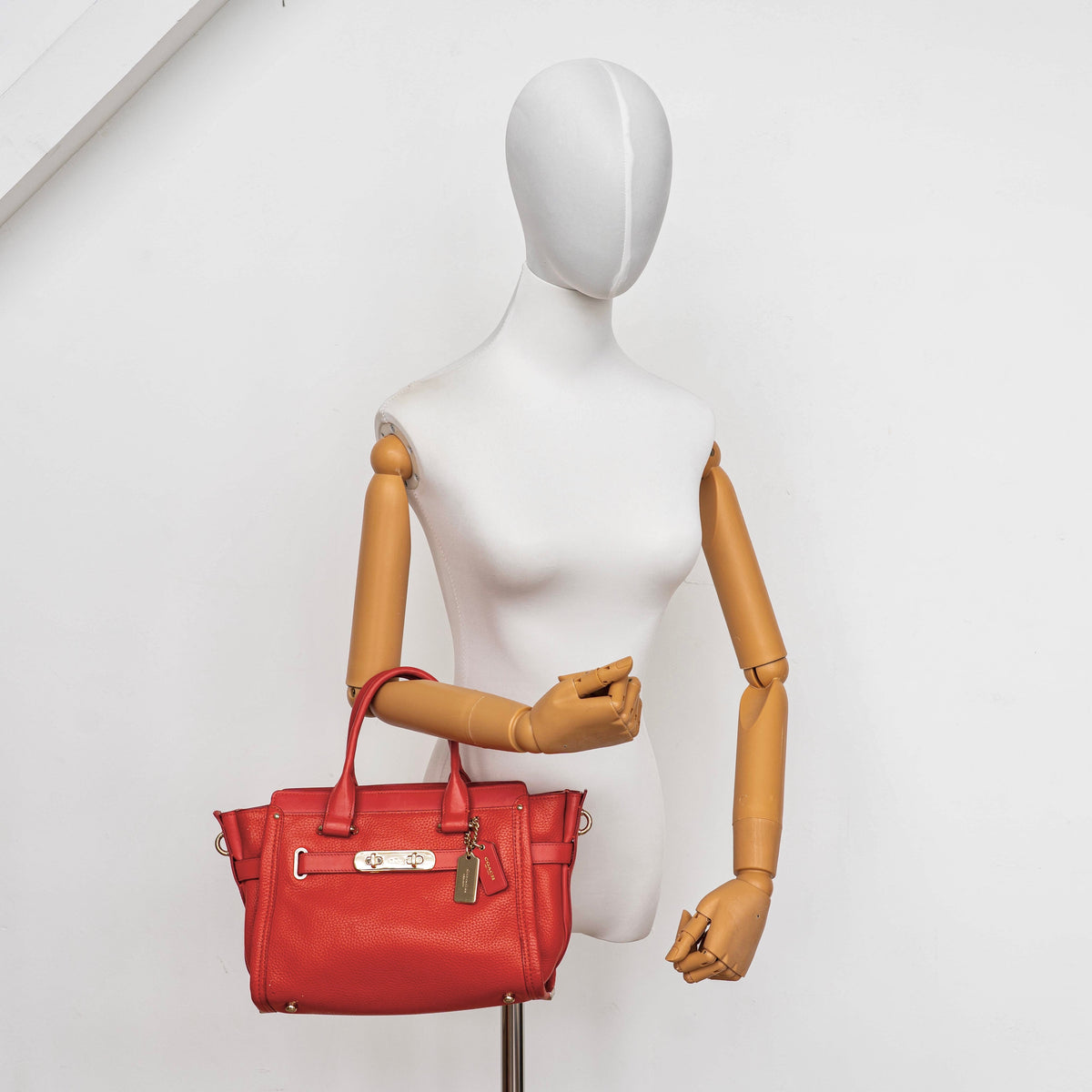 Coach Swagger 27 Carryall in textured red leather with gold hardware, shown with detachable shoulder strap.