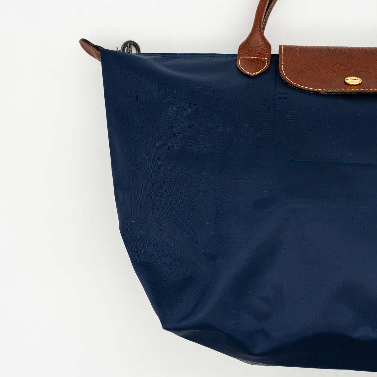 Longchamp Le Pliage Original handbag in navy blue nylon with brown leather handles and trim, shown against a white background.