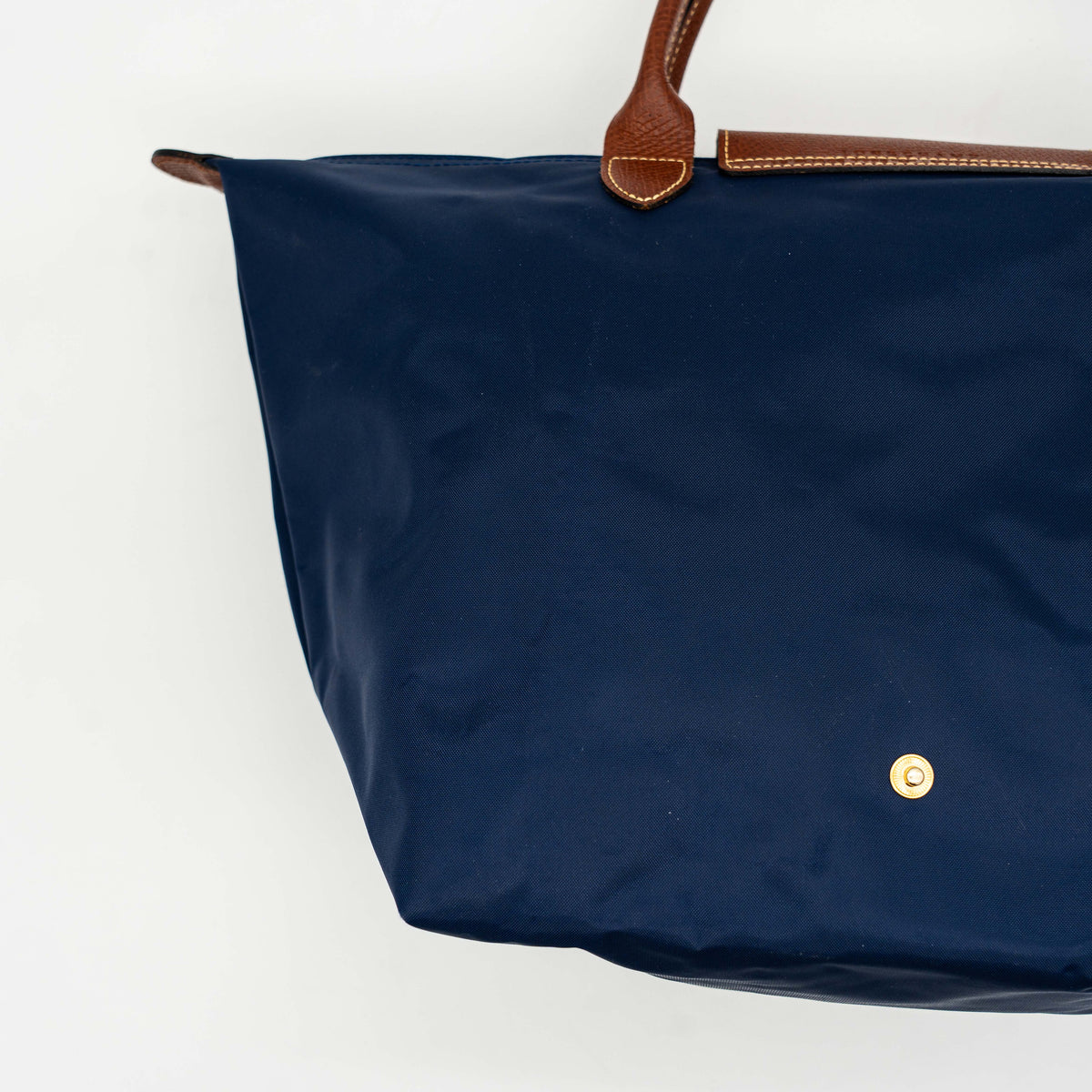 Longchamp Le Pliage Original handbag in navy blue nylon with brown leather handles and trim, shown against a white background.