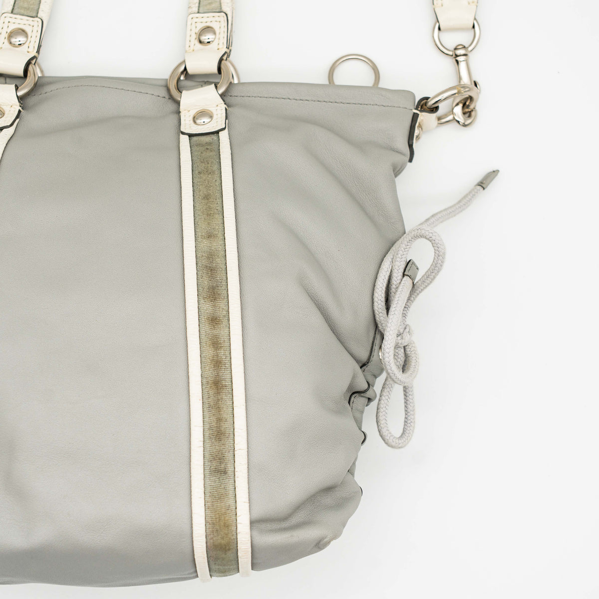 Coach Poppy Spotlight grey shoulder bag with double top handles, white trim, and detachable webbing strap, displayed on a white background.