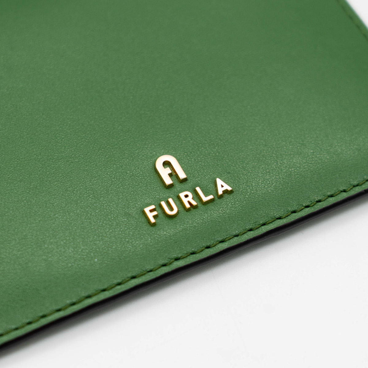 Furla Camelia S zipped card case in green leather with gold hardware and multiple card slots.