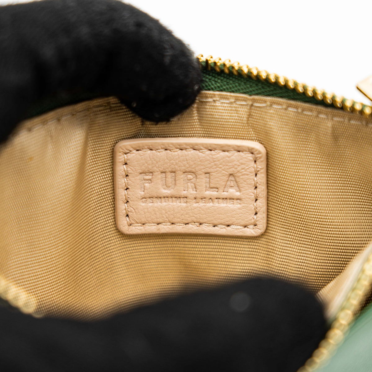 Furla Camelia S zipped card case in green leather with gold hardware and multiple card slots.