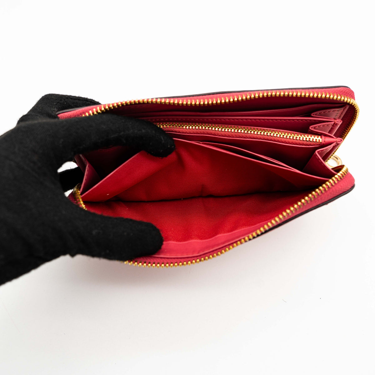 Coach Horse And Carriage Long Zip Around Wallet in red grained leather with gold-tone hardware and embossed logo, shown against a white background.
