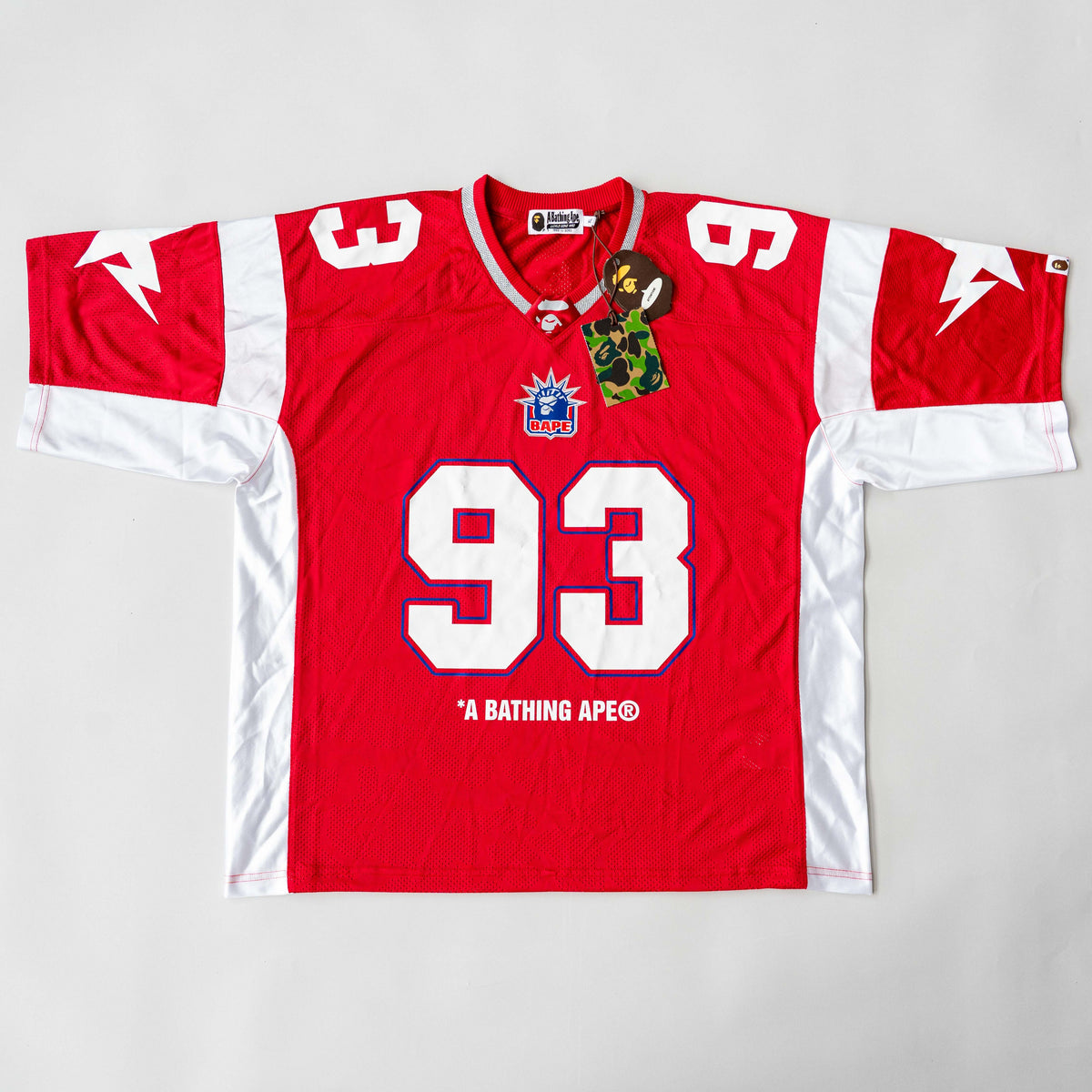 Front view of BAPE Solid Camo Jacquard Mesh Cropped Fit Football Jersey in red and white with bold '93' print and original tags.