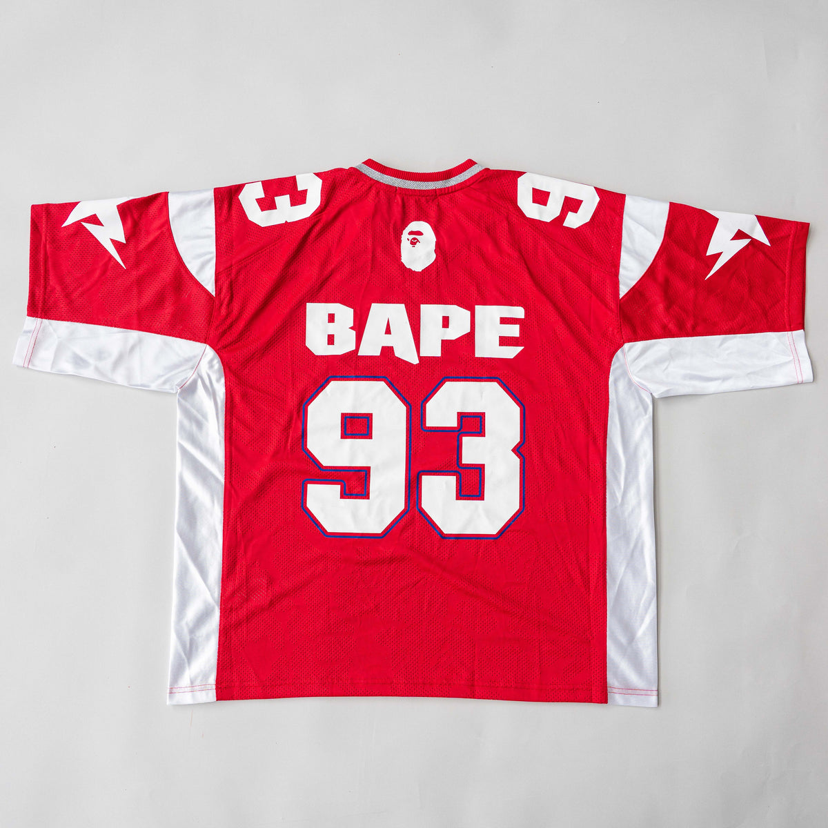 Front view of BAPE Solid Camo Jacquard Mesh Cropped Fit Football Jersey in red and white with bold '93' print and original tags.