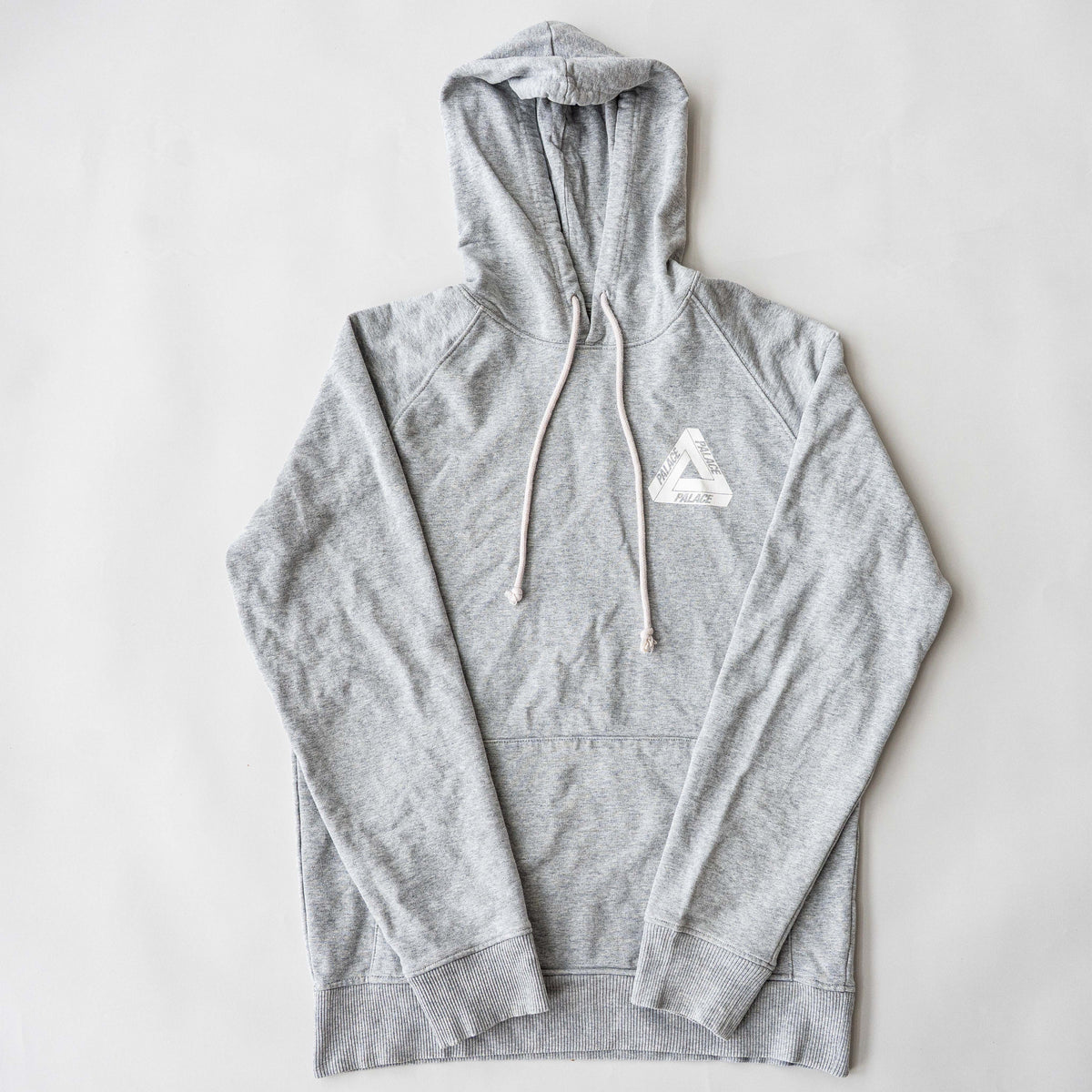 Palace grey pullover hoodie with tropical Tri-Ferg back graphic and white chest logo, laid flat on a neutral background.