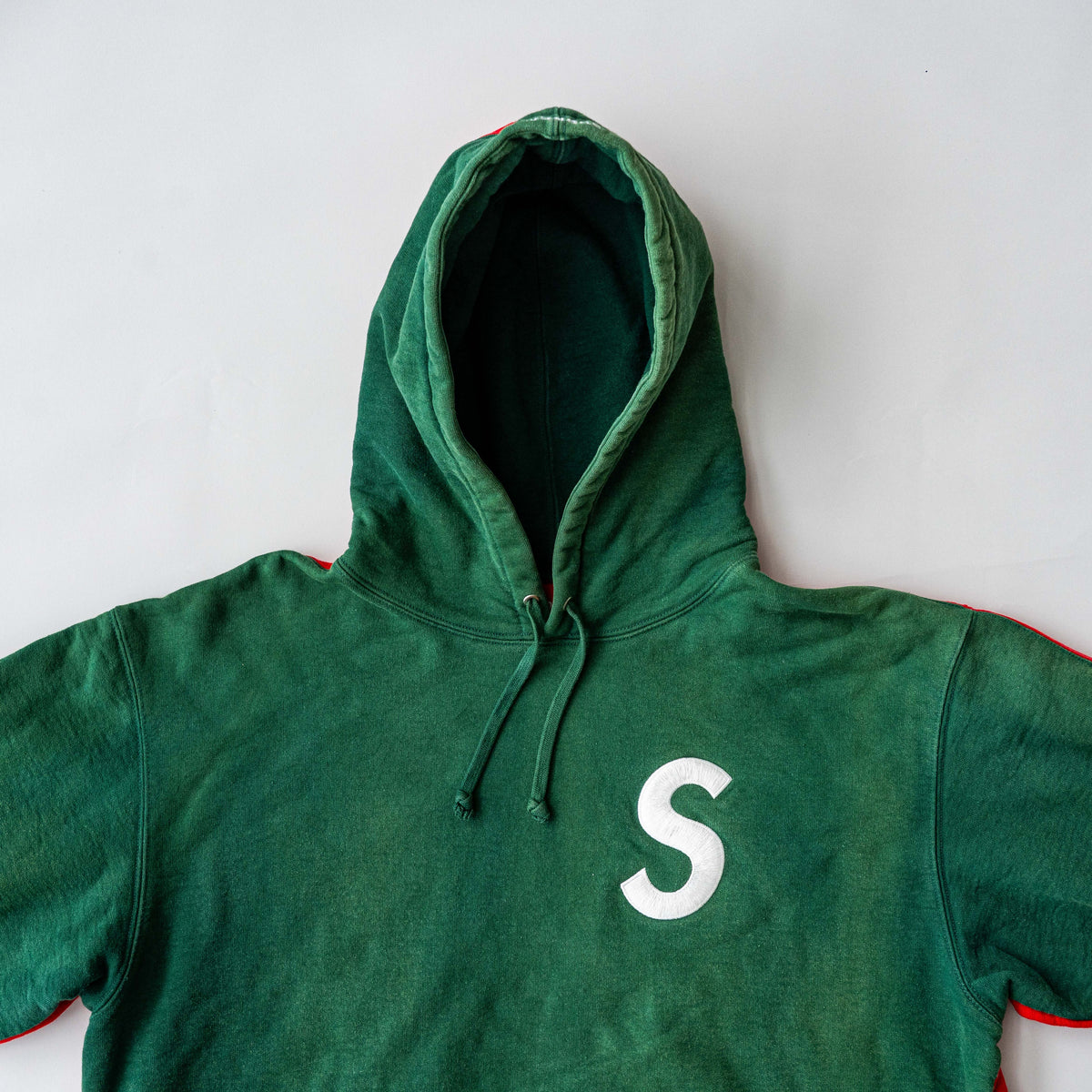 Supreme S Logo Split Hooded Sweatshirt in dark green and red, featuring front 'S' patch and a bold colour contrast.