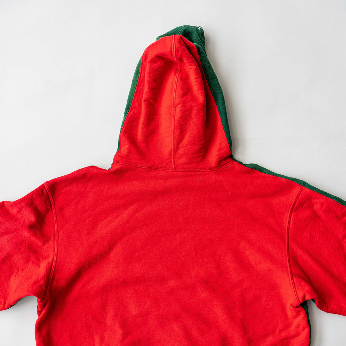 Supreme S Logo Split Hooded Sweatshirt in dark green and red, featuring front 'S' patch and a bold colour contrast.