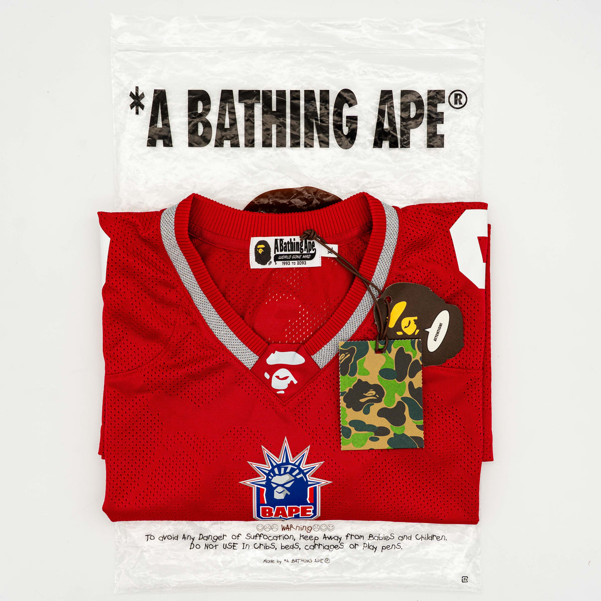 Front view of BAPE Solid Camo Jacquard Mesh Cropped Fit Football Jersey in red and white with bold '93' print and original tags.