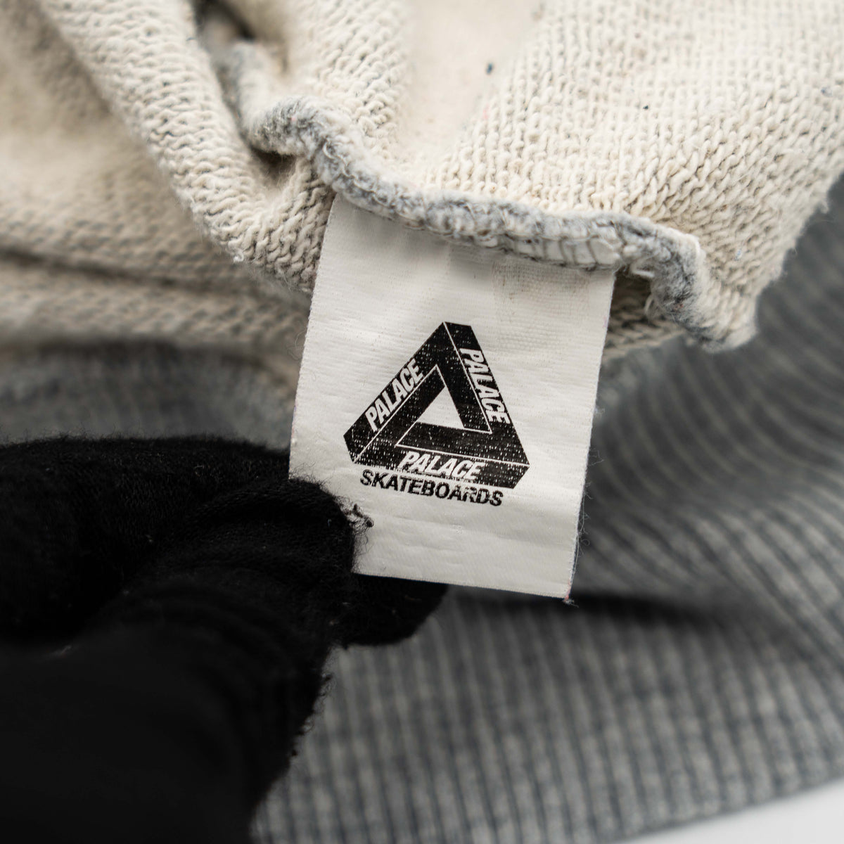 Palace grey pullover hoodie with tropical Tri-Ferg back graphic and white chest logo, laid flat on a neutral background.