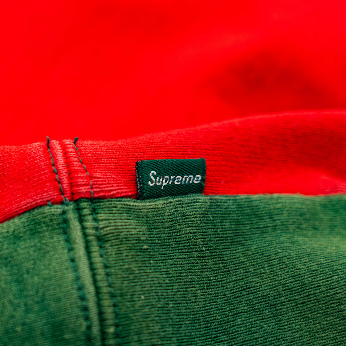 Supreme S Logo Split Hooded Sweatshirt in dark green and red, featuring front 'S' patch and a bold colour contrast.