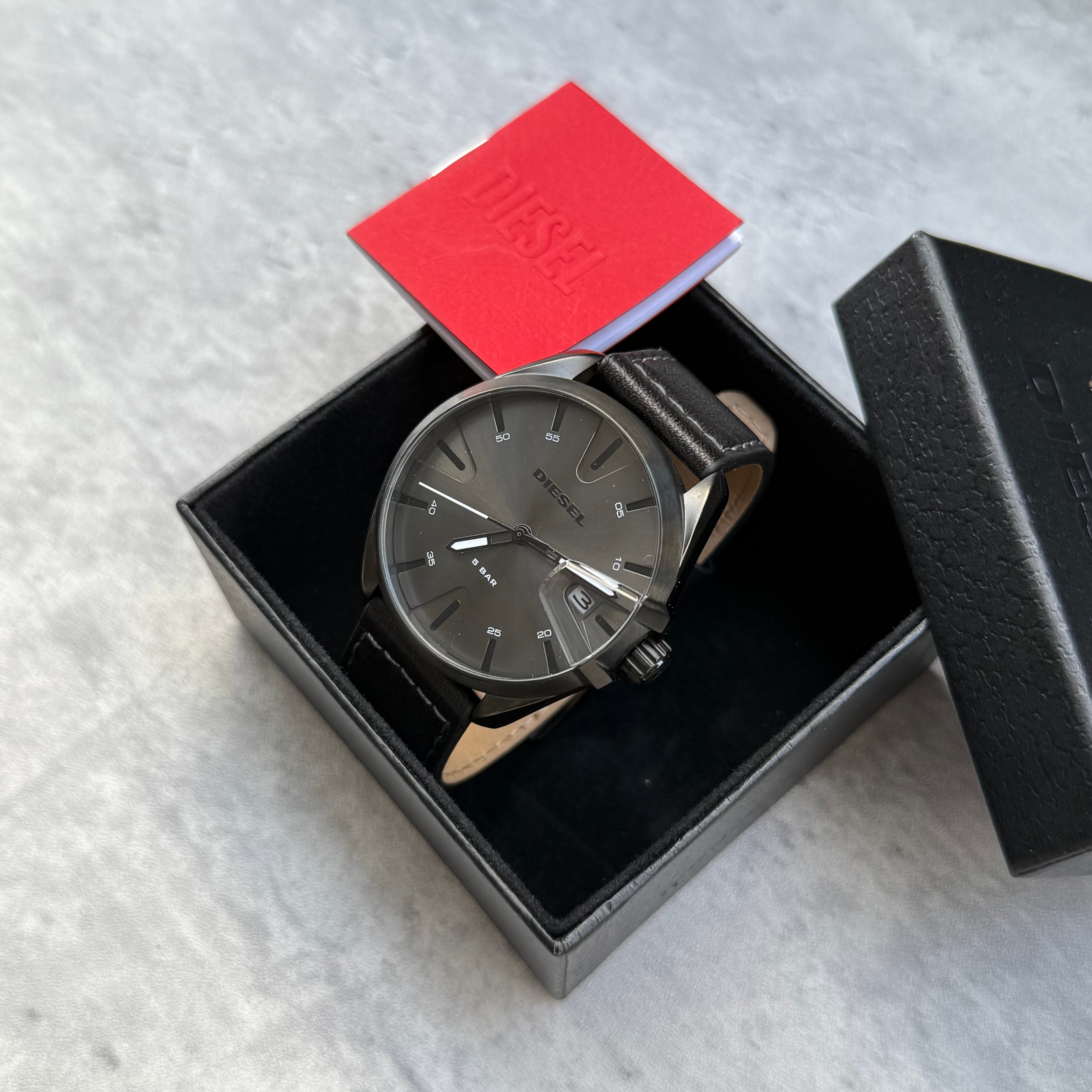 Pre-loved Diesel DZ1924 MS9 three-hand black leather watch with silver-tone dial, shown with original box and booklet