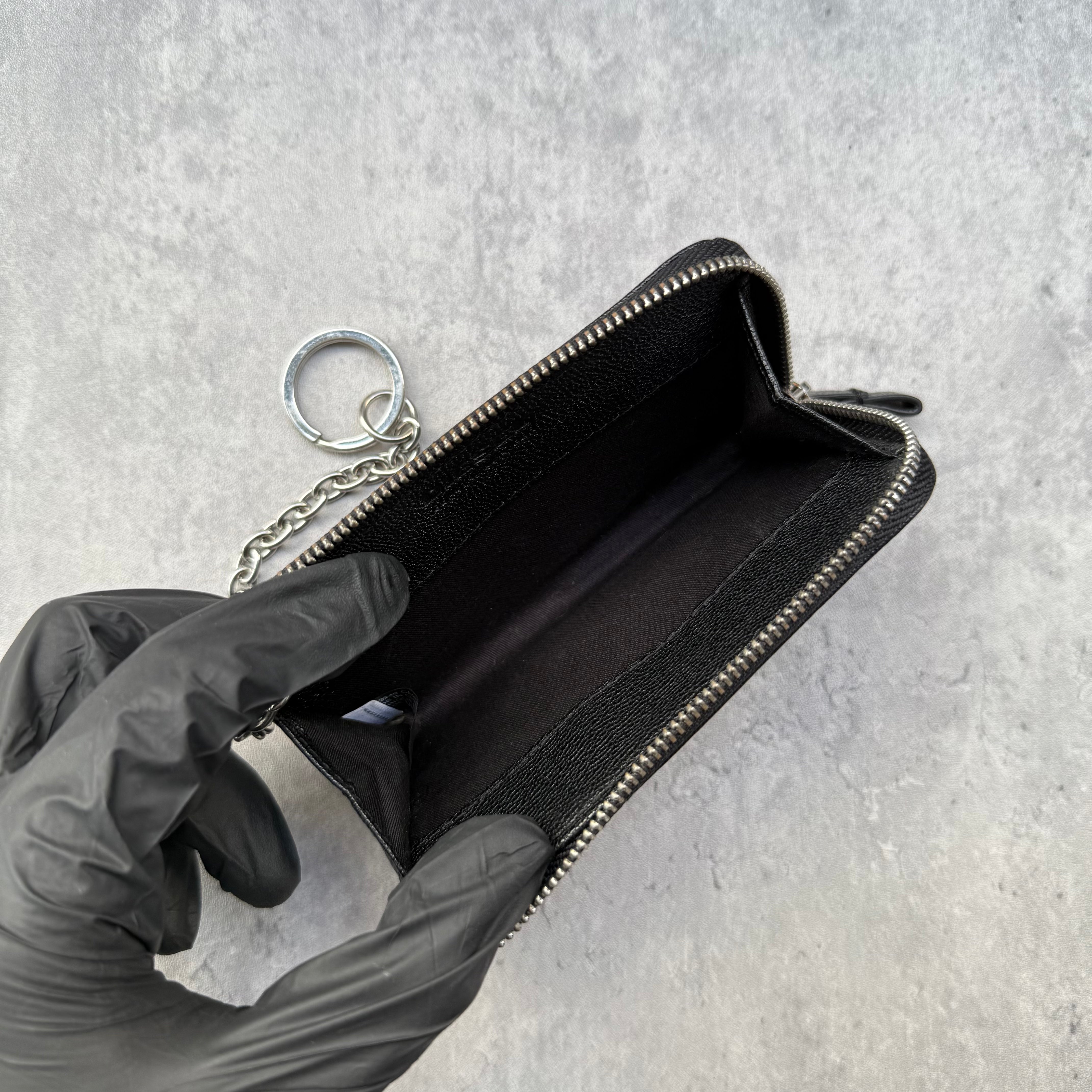 Diesel Key Coin Case Wallet in black leather with silver logo, zip closure, and attached chain keyring.