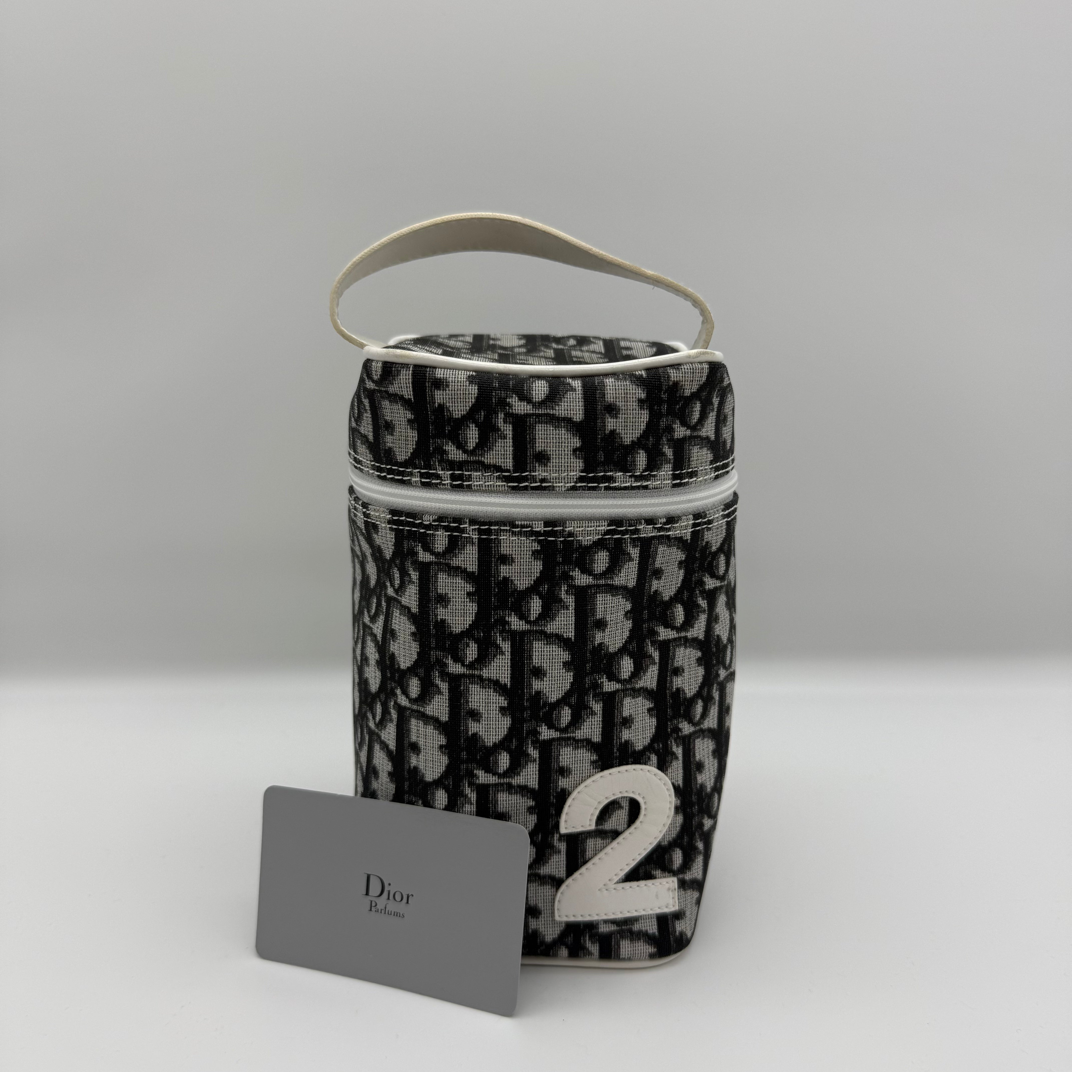 Dior Trotter cosmetic pouch in black/grey jacquard with white leather trim, zip-around lid, and “2” appliqué — pre-loved.