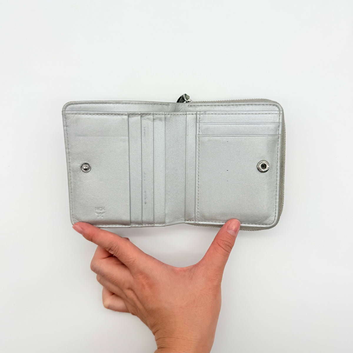 MCM Visetos Monogram wallet in metallic silver with black logo pattern on a clean white background.
