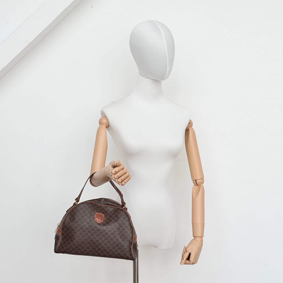 Front view of the Celine Triomphe Macadam Dome Handbag in brown, featuring the signature monogram canvas and tan leather details.