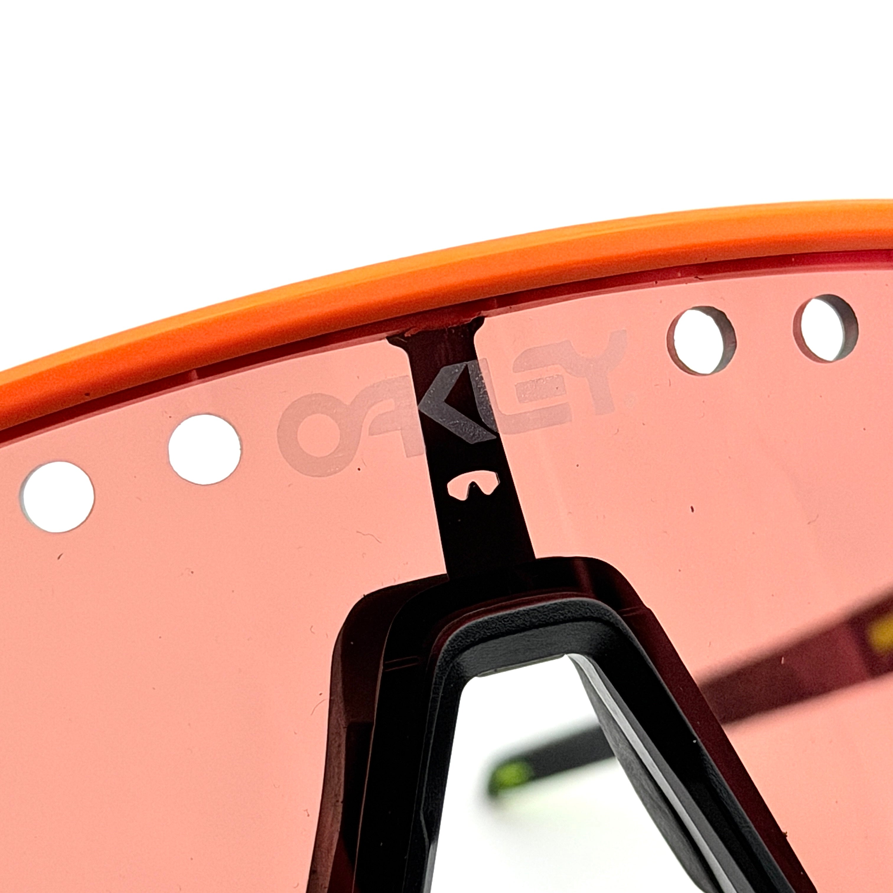 Oakley Sutro Lite Sweep sunglasses in neon yellow and orange with Prizm Trail Torch shield lens, displayed with box and case.
