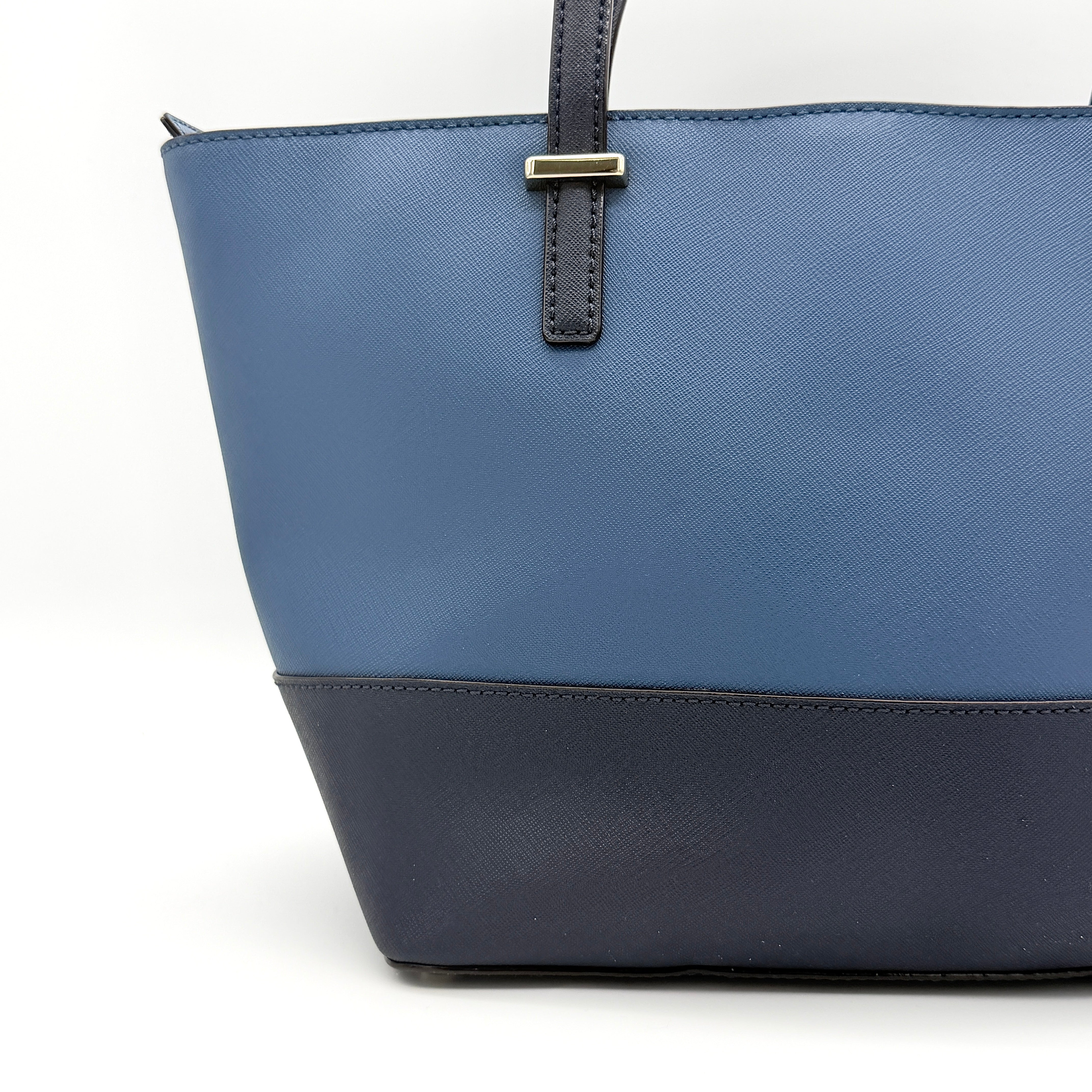 Kate Spade New York leather tote in two-tone blue with gold-tone hardware and structured handles.