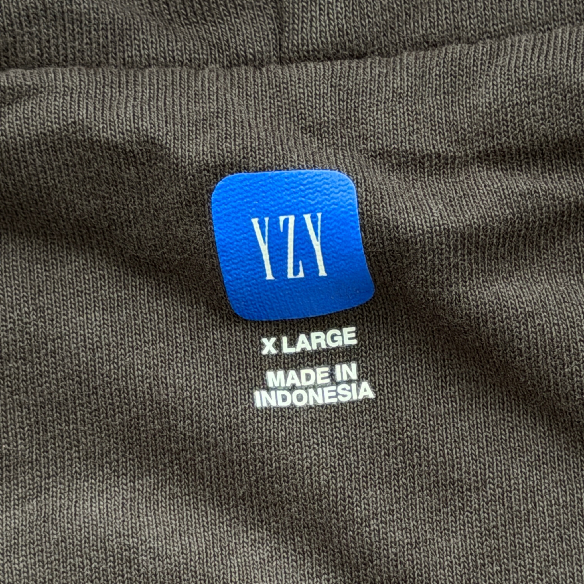 Yeezy x Gap black XL zip up hoodie with hood and front pocket, laid flat showing entire front.