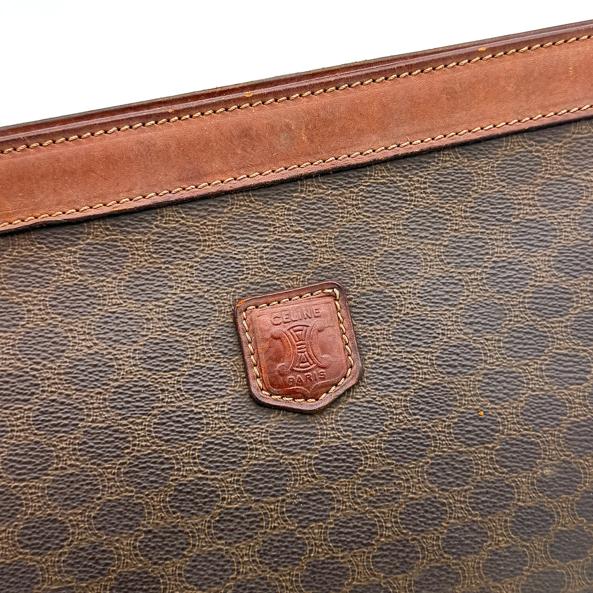 Celine Triomphe Macadam Clutch Bag in brown coated canvas with leather trim, photographed on a white background.