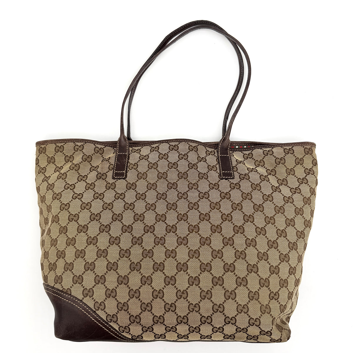 Gucci GG Monogram New Britt Tote Bag in beige and brown canvas with leather trim and gold-tone logo, presented against a white backdrop.