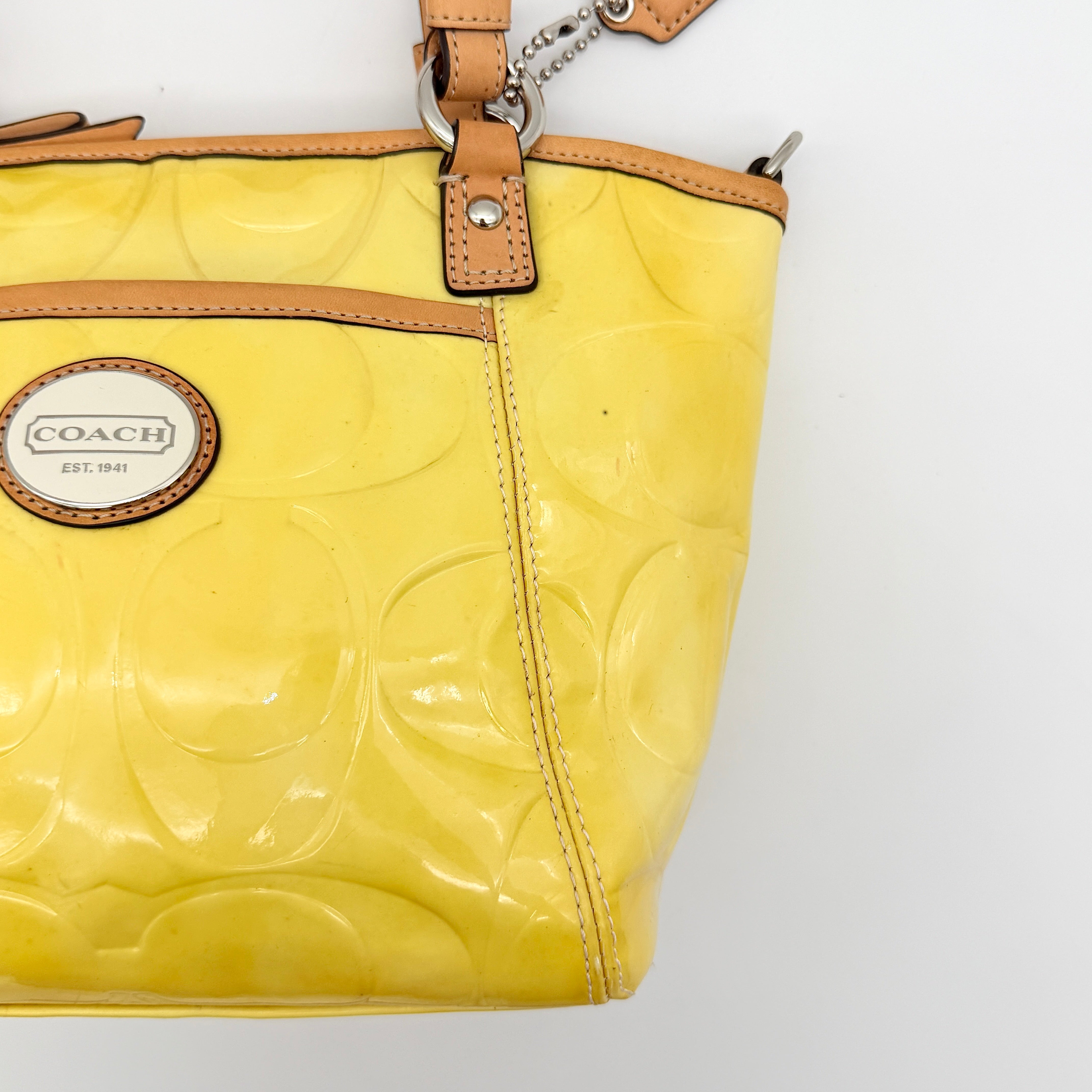 Coach Peyton tote in glossy yellow patent leather with tan handles and detachable strap, shown with blush pink interior.