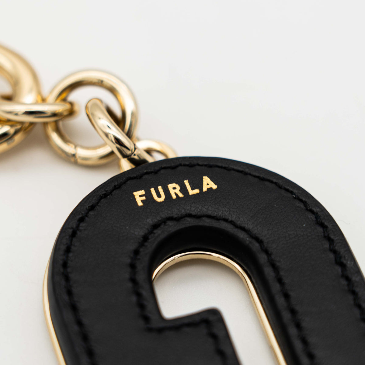Furla Venus Arch Logo keychain in black leather with gold-tone hardware and clasp.