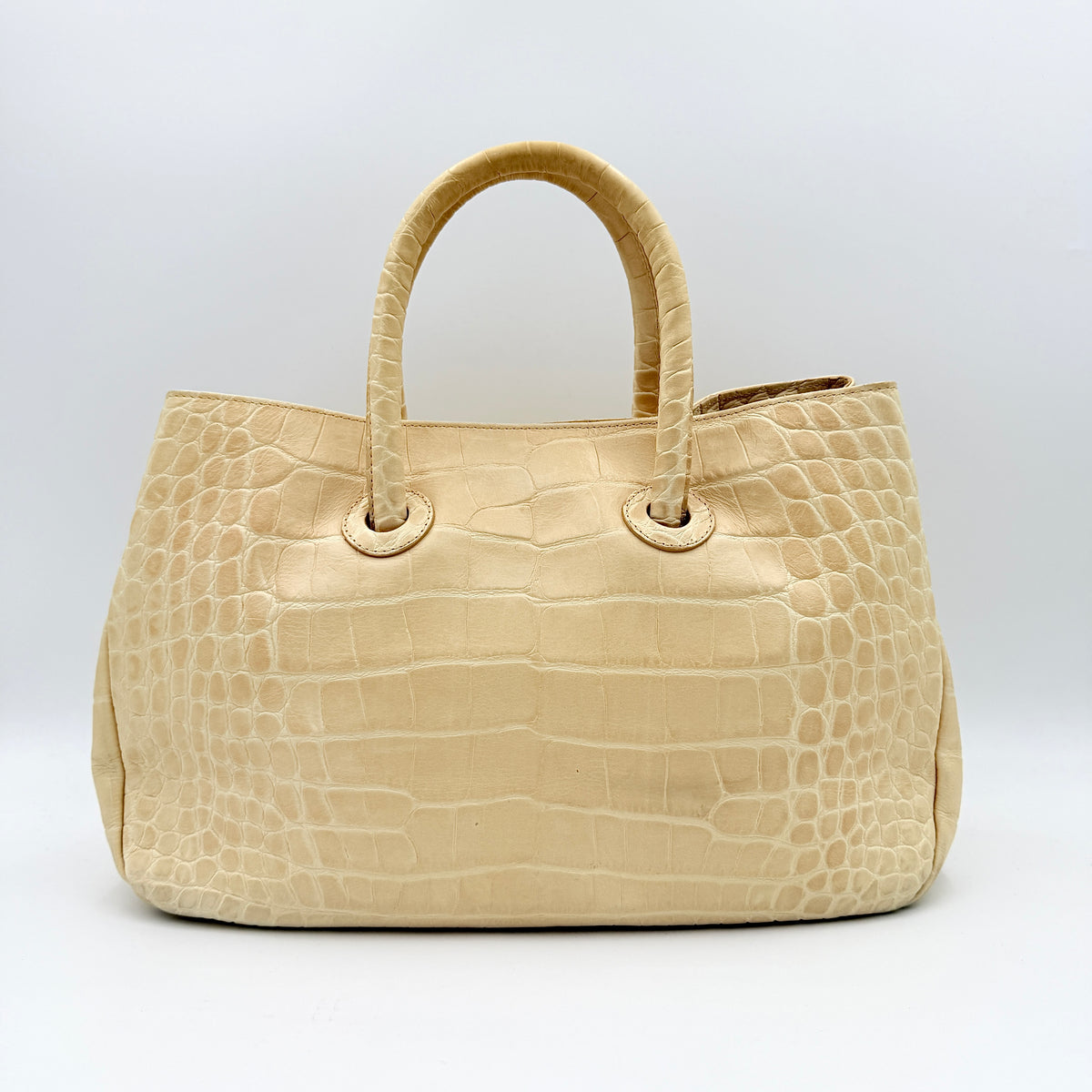 Furla beige croc-embossed leather handbag with double handles and silver-tone logo medallion, photographed on a white background.