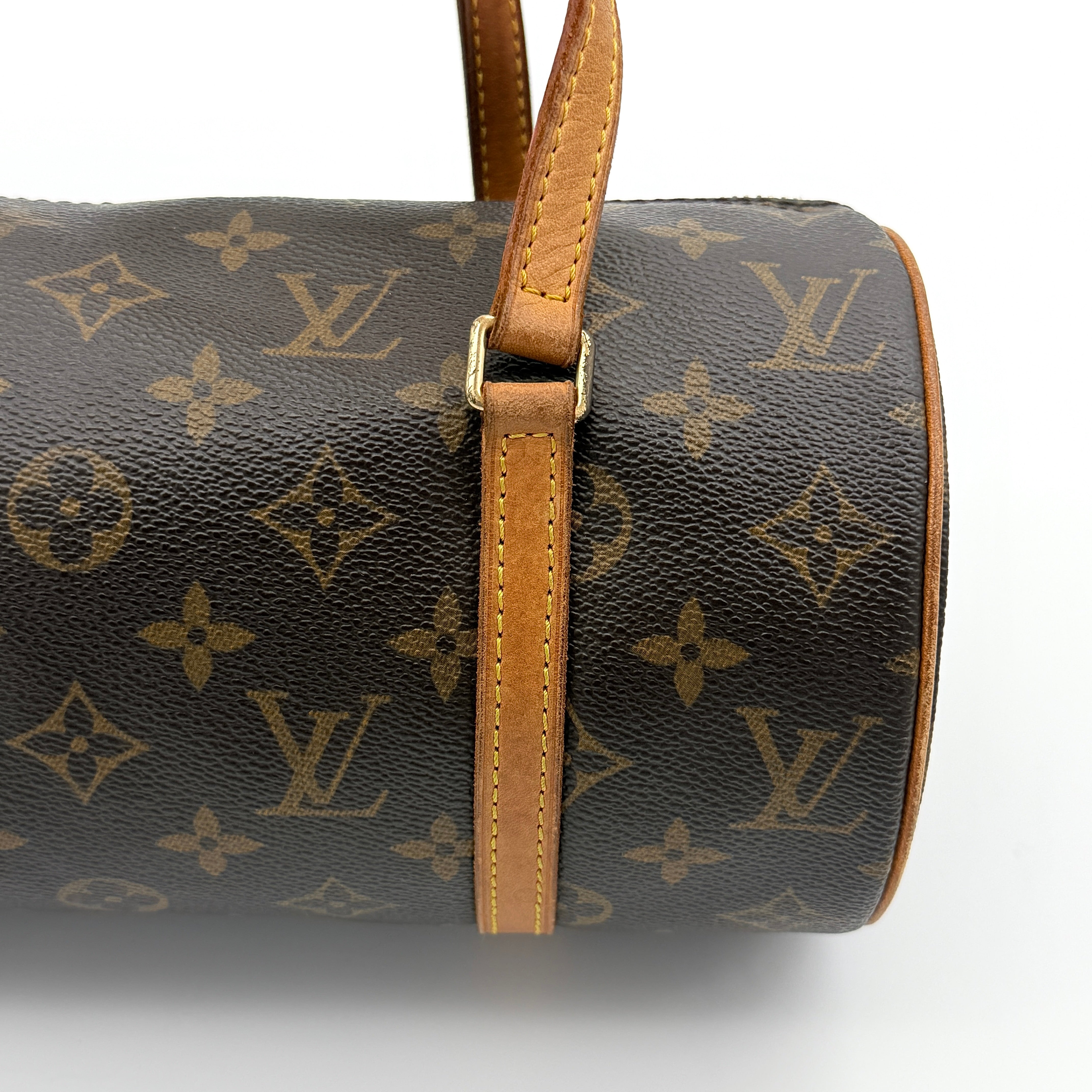 Louis Vuitton Papillon 26 in Monogram canvas with brown leather trim and gold-tone zip, shown against a white background.
