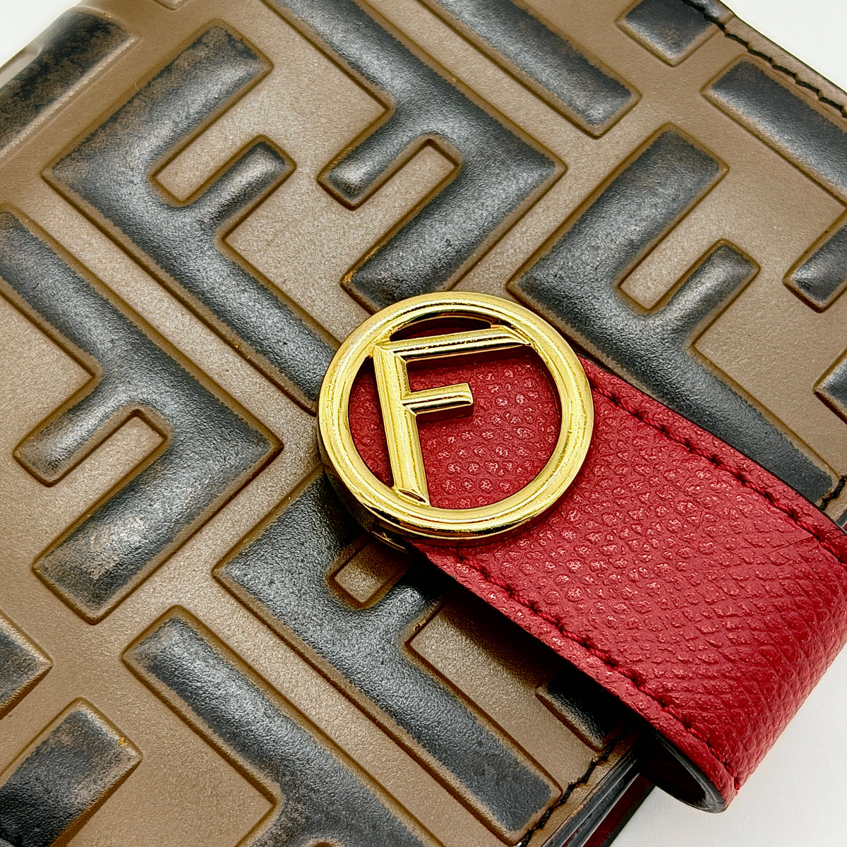 Fendi FF Embossed Logo Bifold Wallet in brown with red strap and gold Fendi hardware, displayed front on white background
