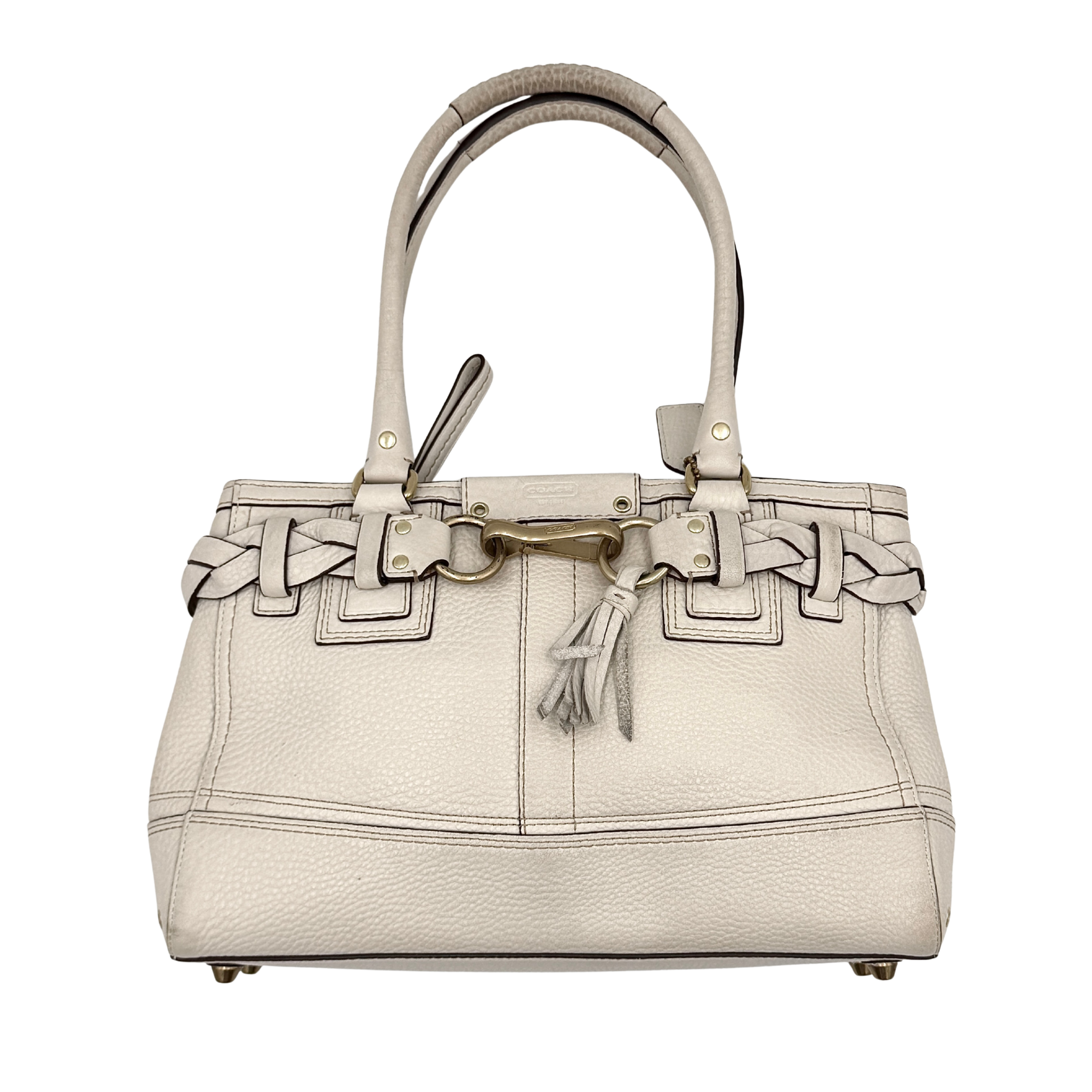 Coach Hampton Carryall in ivory leather with braided trim, brass dogleash clip, tassel, and top handles displayed against a white background.