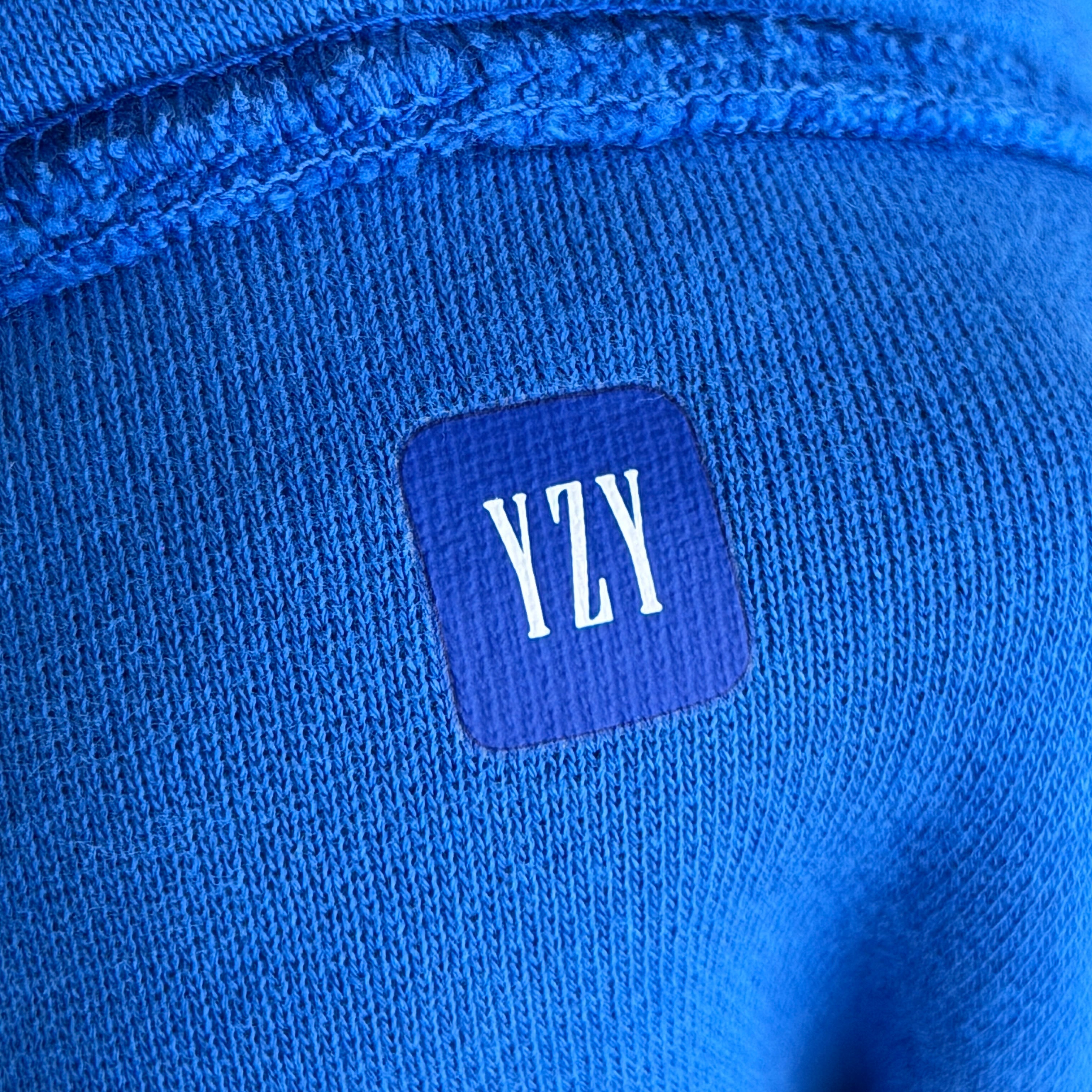 Yeezy x Gap hoodie in vivid blue with a relaxed fit and front pocket, presented by Elevated Studios.