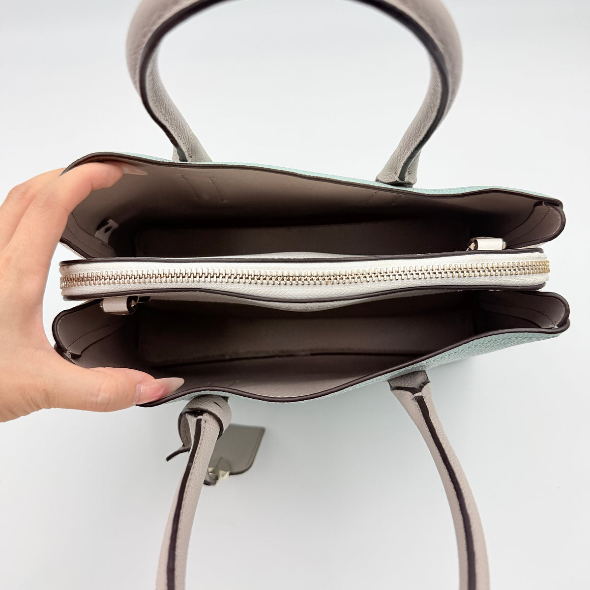 Kate Spade New York Margaux satchel in mint green pebbled leather with taupe handles, shown with its detachable strap and a clear pouch.