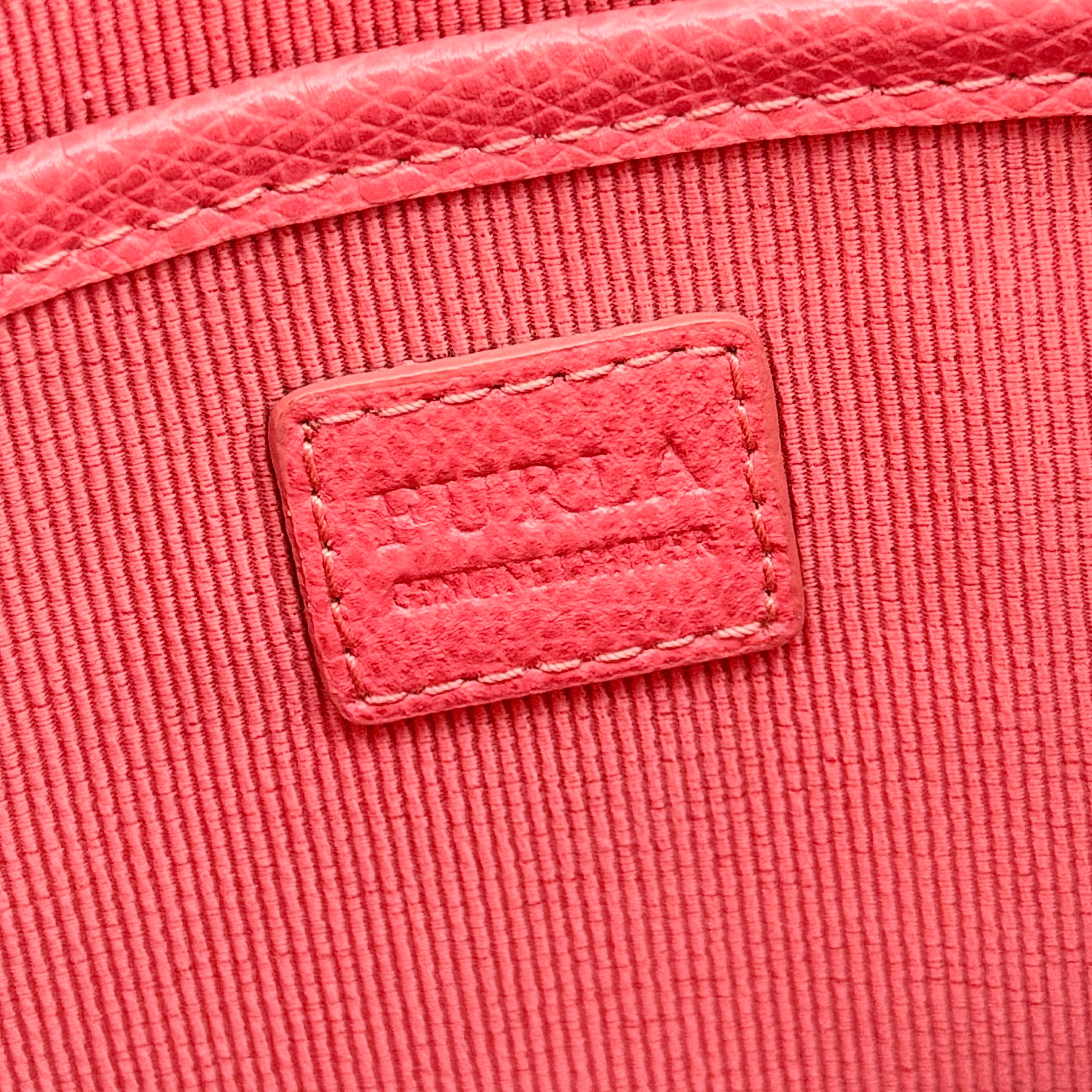 Furla pink leather crossbody bag with gold zip and adjustable strap, photographed flat on a white background.