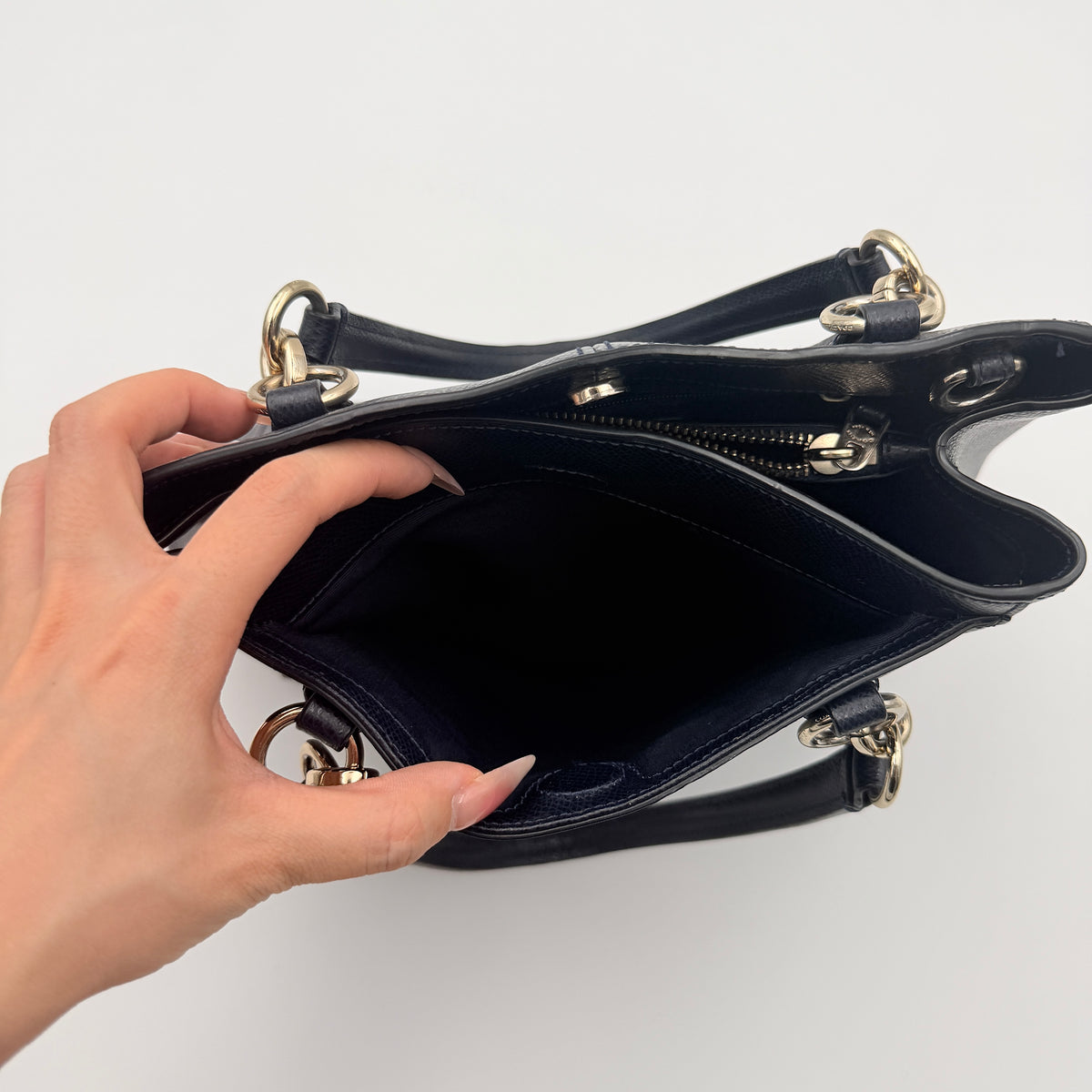 Coach Minetta Satchel in navy blue grained leather with dual handles and detachable shoulder strap displayed on a white background.