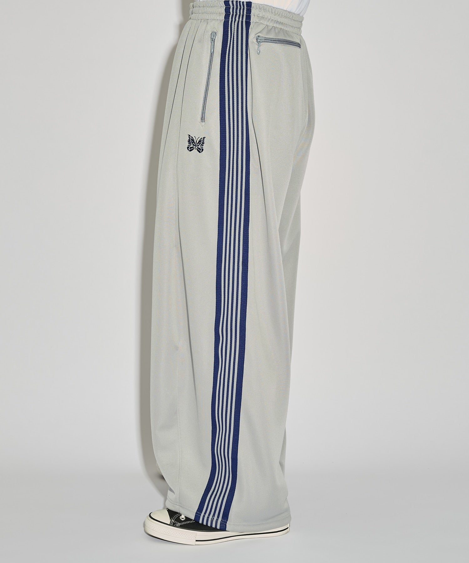 Grey Needles H.D. Track Pant with blue side stripes and butterfly logo, shown from a side angle.