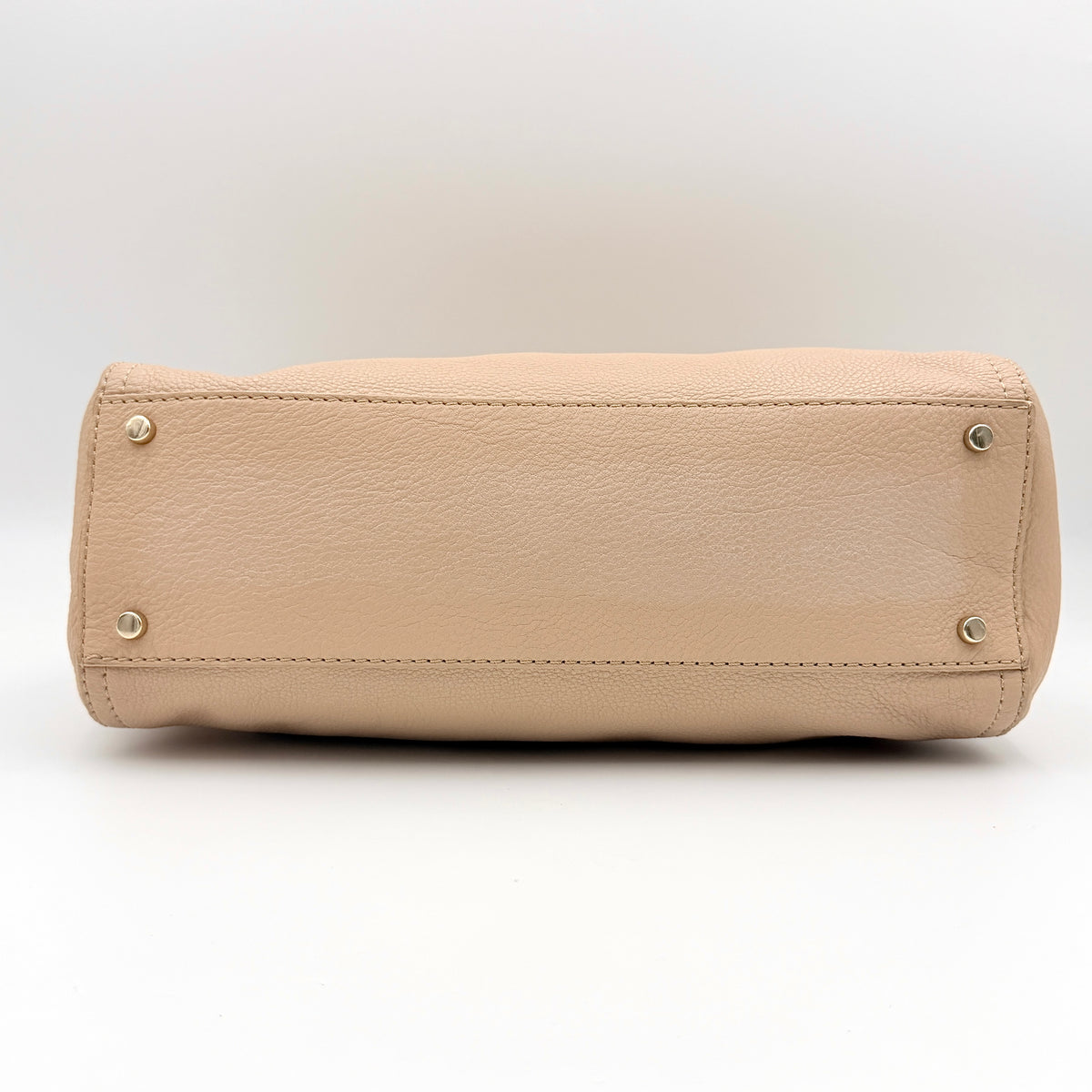 Kate Spade Cobble Hill Little Minka in beige pebbled leather with both top handle and detachable strap displayed.