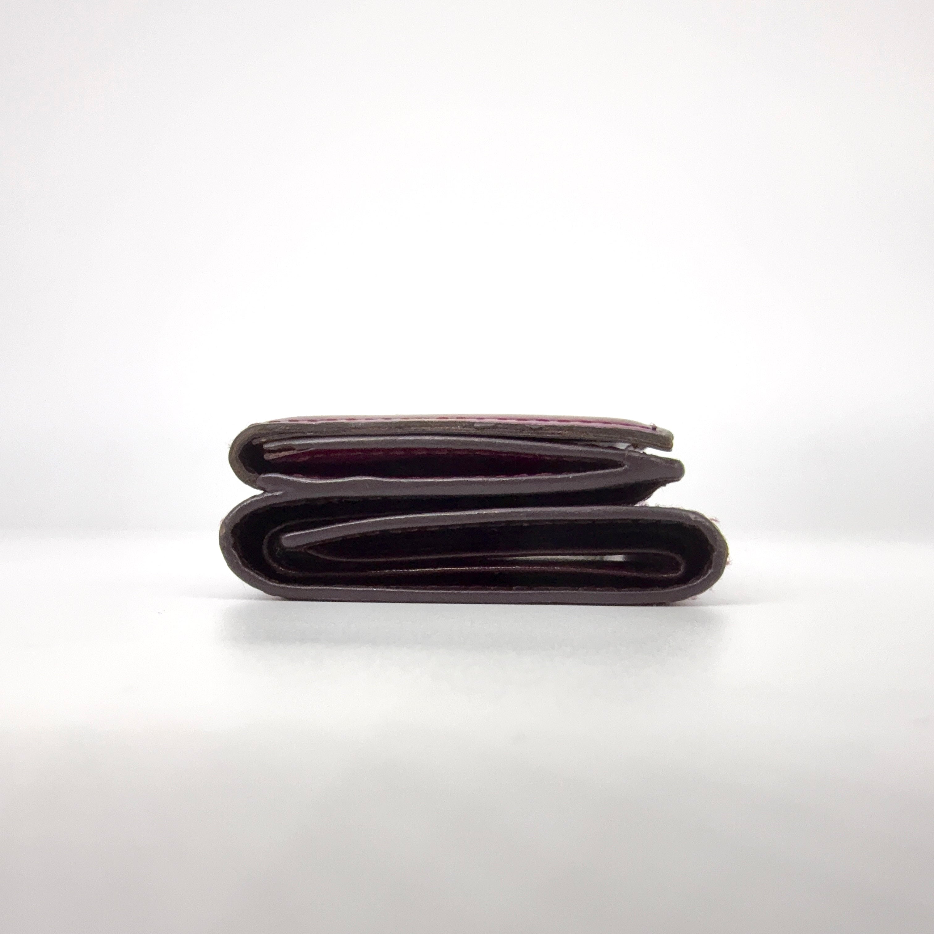 Vivienne Westwood Signature Orb Wallet in glossy purple leather with silver orb emblem on the front flap.