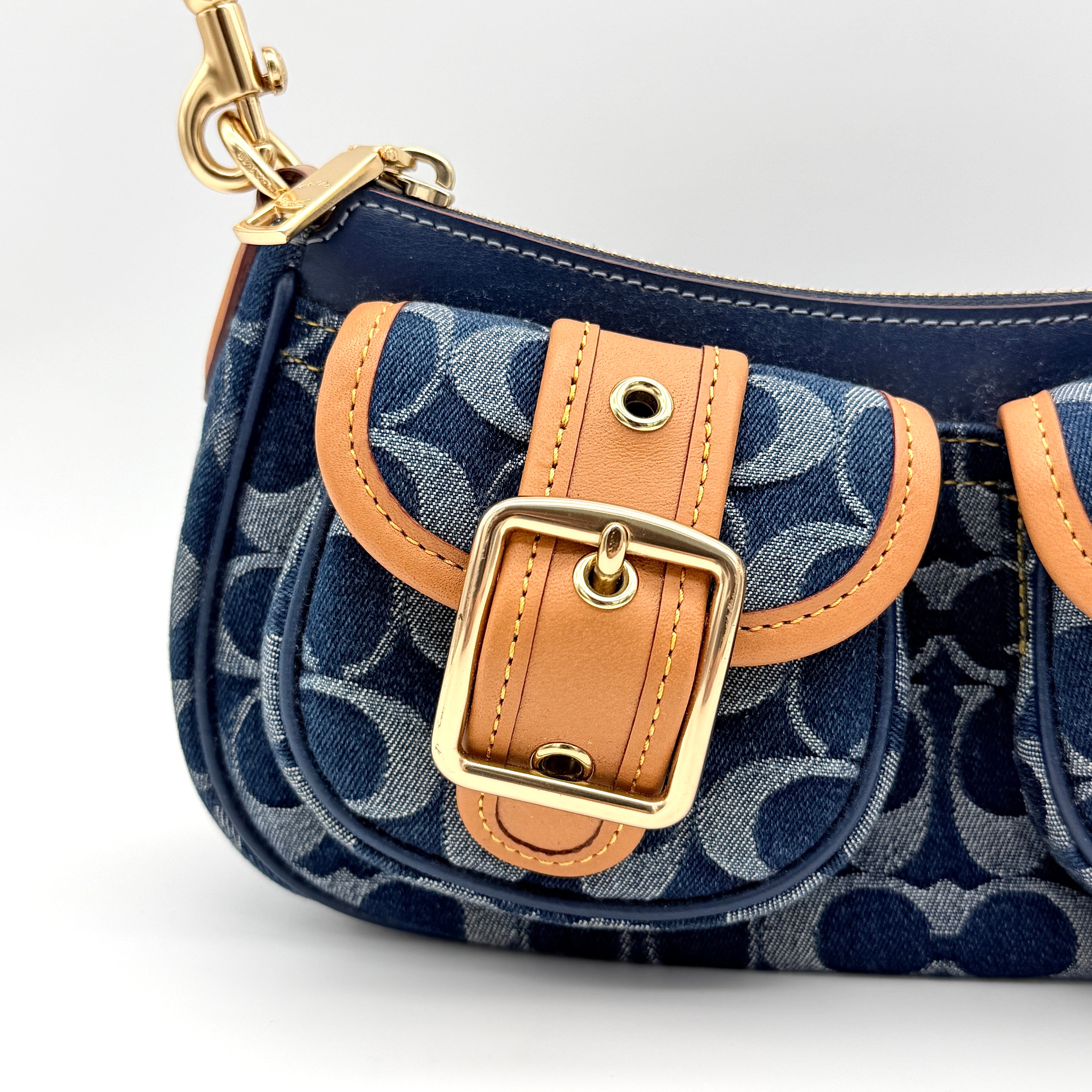 Coach Signature Ashton shoulder bag in blue denim and tan leather with gold hardware, shown with removable strap and dust bag.