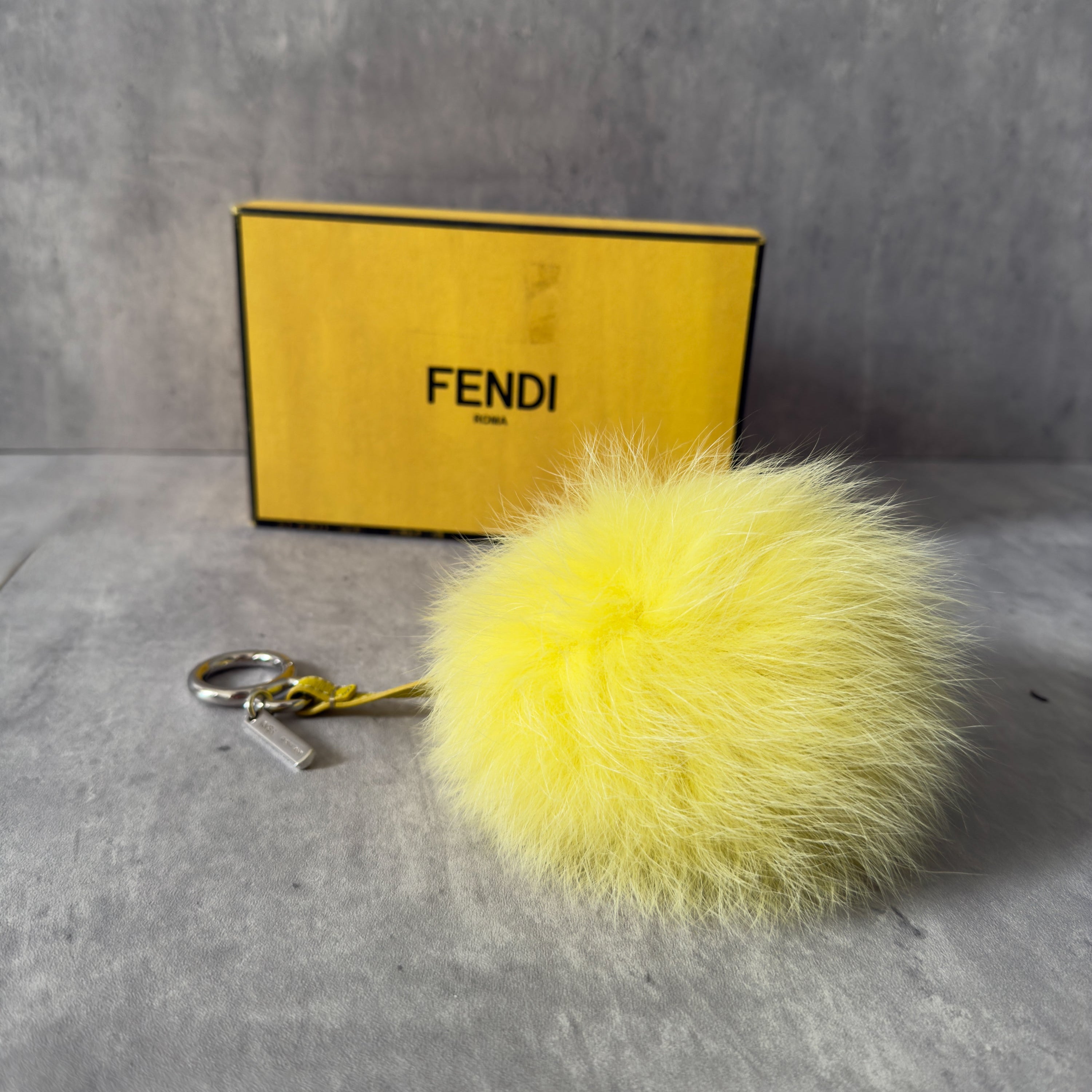 Fendi Yellow Fur Bag Charm with plush fox fur, silver-tone keyring, and leather strap.