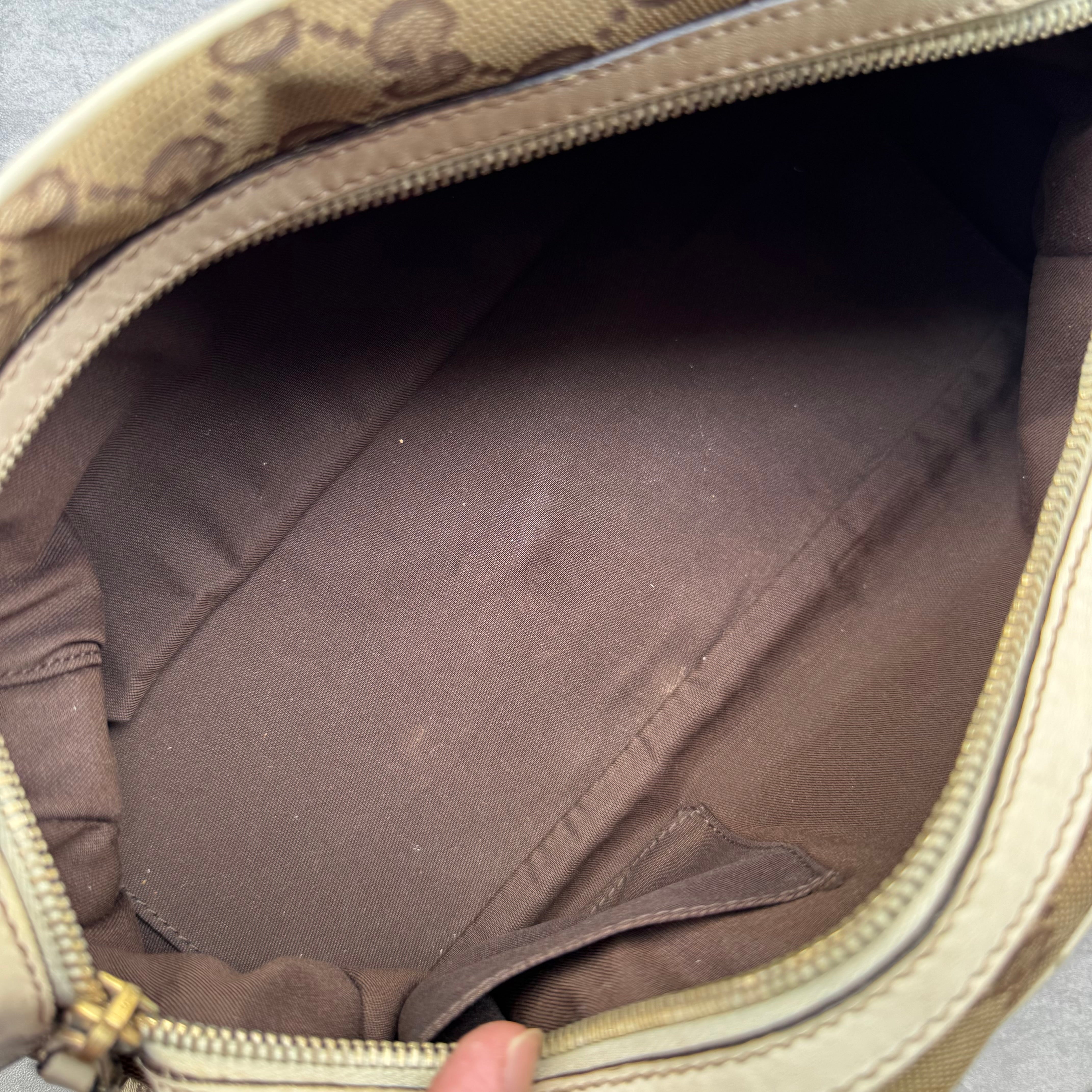 Gucci GG Canvas Trophy Boston Bag in beige monogram canvas with cream leather trim and floral GG emblem detail.