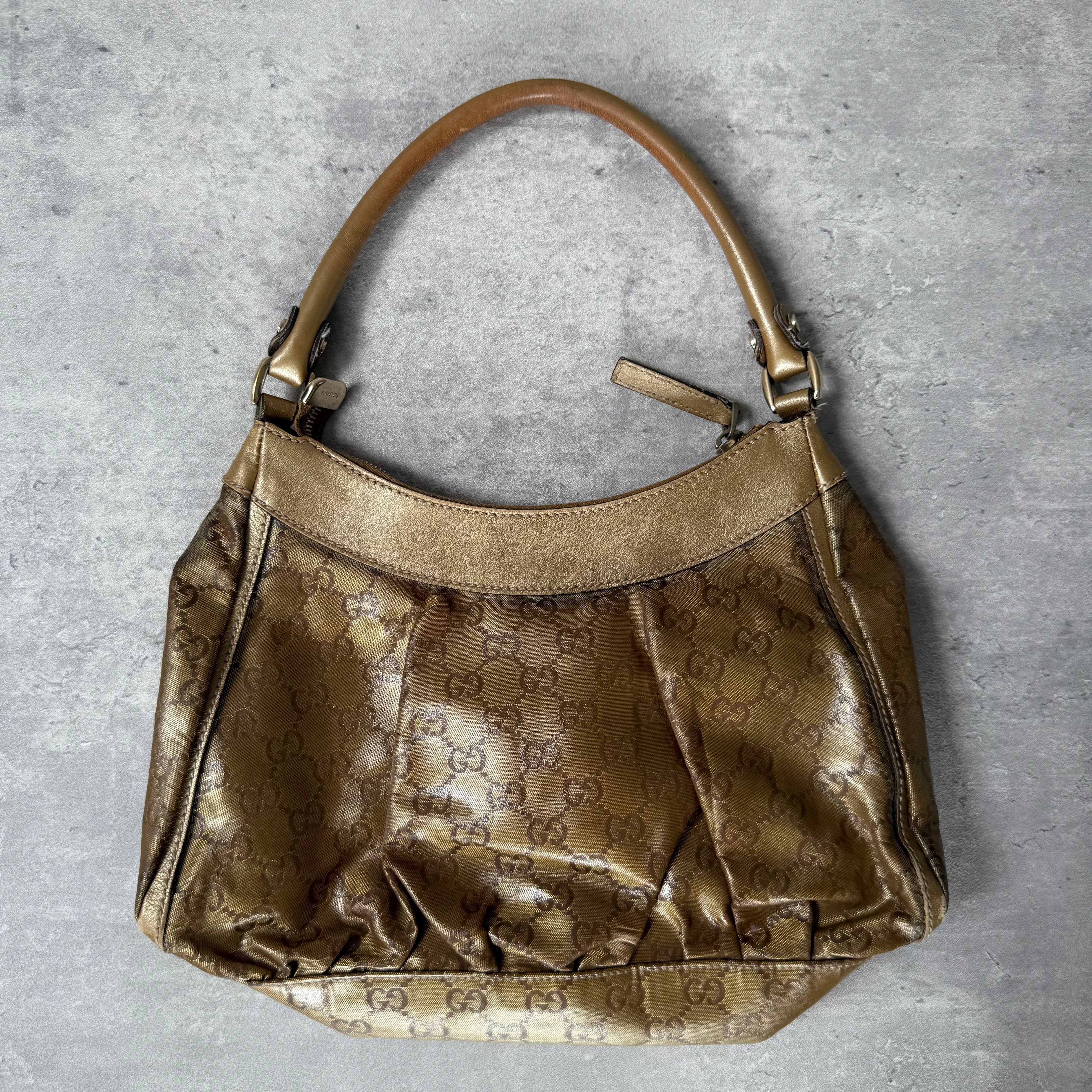 Gucci GG Monogram D-Ring Shoulder Bag in metallic gold with patent leather trim, pleated body, and gold-tone hardware.